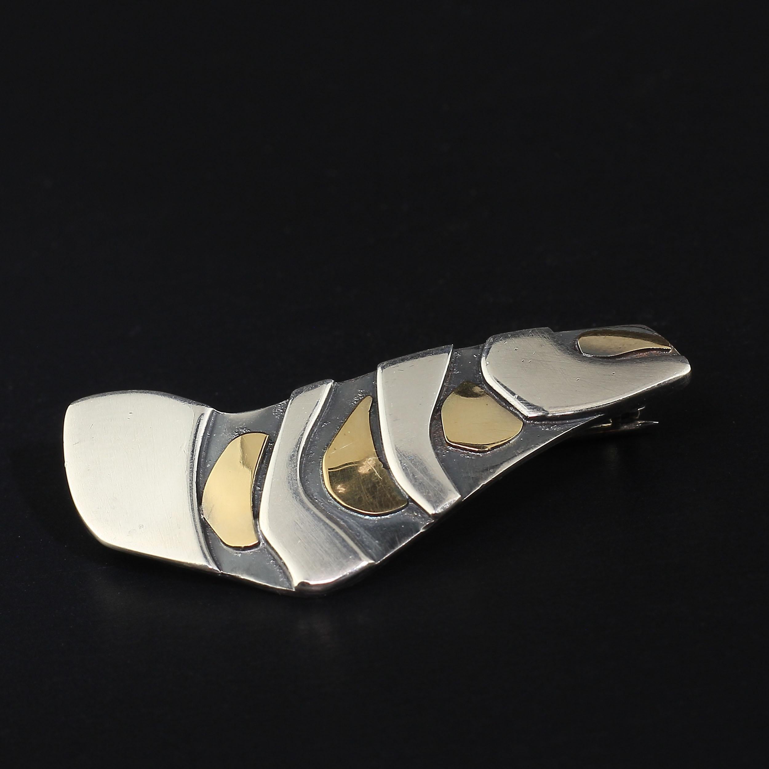 Contemporary, elegant stylized bird brooch created in Sterling Silver and 18K yellow Gold.  This one of a kind Hans Stahr original is perfect for lapels, scarves, and shawls. Hans is a well known jewelry designer in Rio de Janeiro who has won many