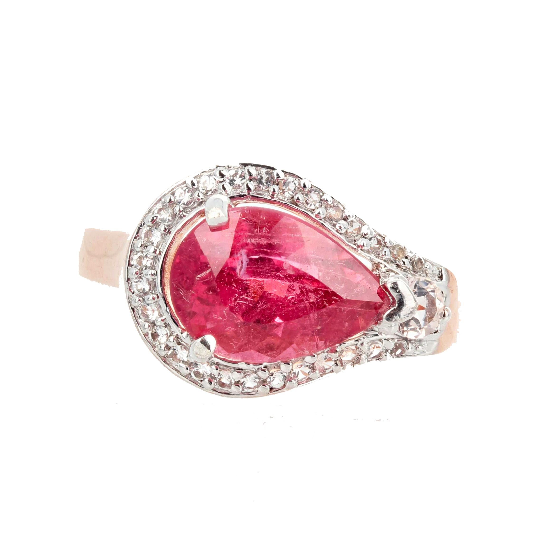 This glittering pear gem cut Pinky Reddish Tourmaline is set in a rose gold plated sterling silver ring size 7 (sizable) and is enhanced with tiny little white diamonds.  This goes happily to dinner or parties.  