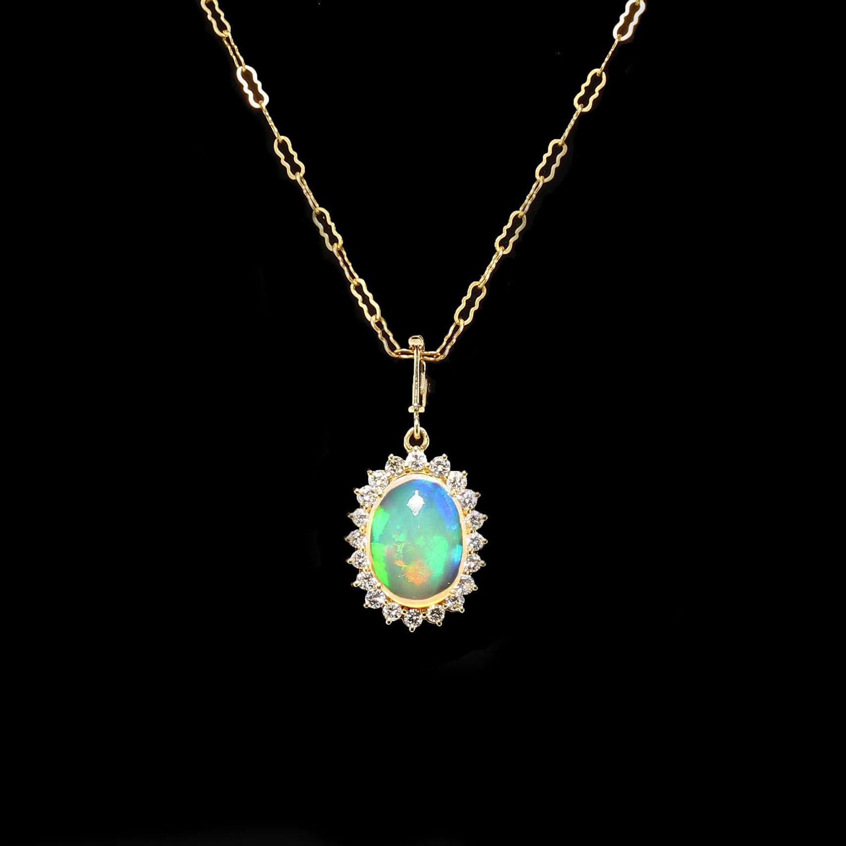 Gorgeous Opal and Diamond pendant with firely orange, green, and blue flashes.  This unique hand made pendant features a cabachon Opal (15 X 11 MM) surrounded by 20 Diamonds of approximately 0.65 ctw, G/H/I color, VS2-SI1 clarity.  It is 1.25 inches