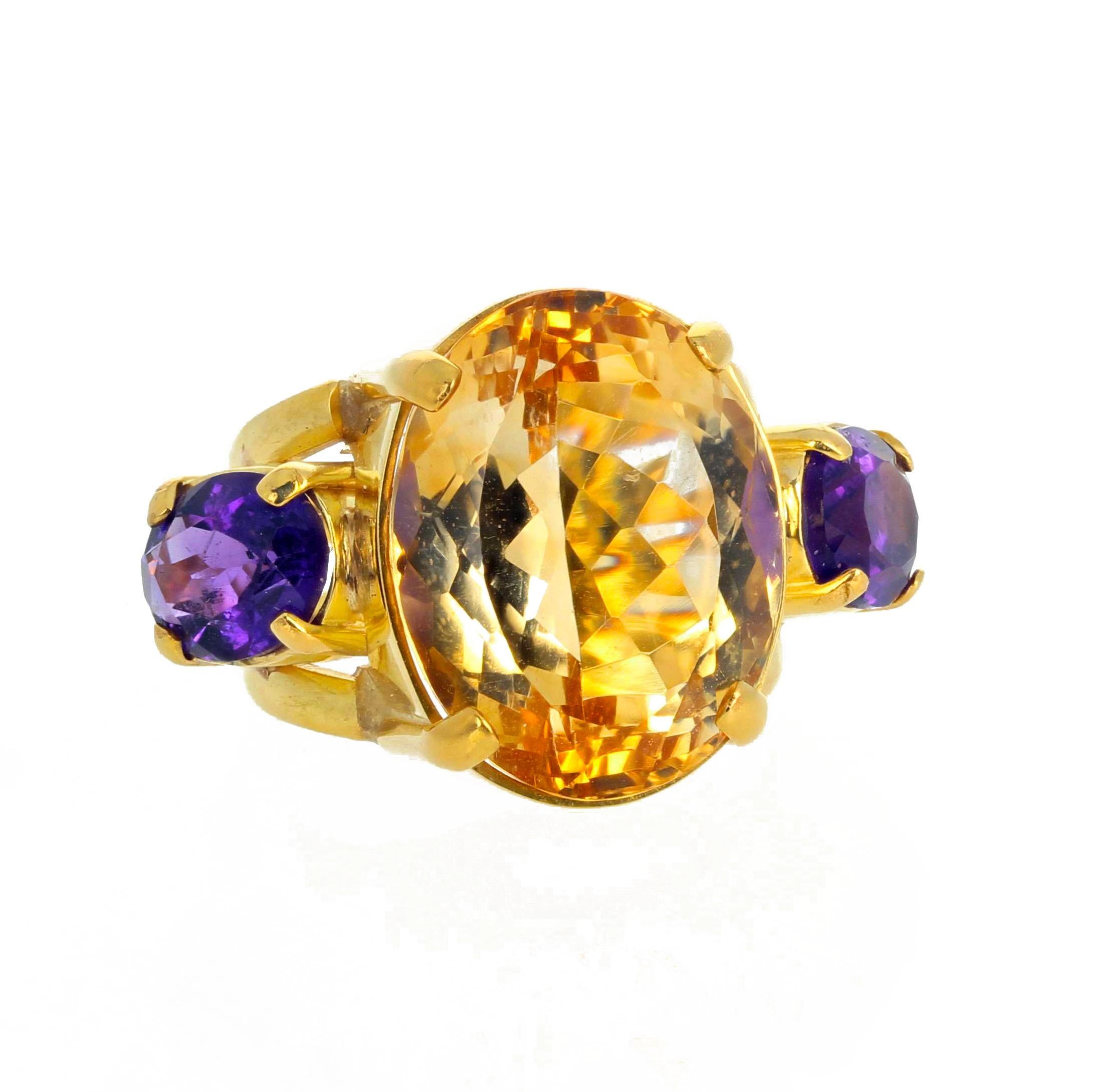 Cette bague de taille cocktail se place très haut sur votre main dans cette monture en or jaune 18K faite à la main.  Les pierres latérales en améthyste (environ 1,8 carat chacune) complètent admirablement la Citrine de 26 carats au centre, d'une