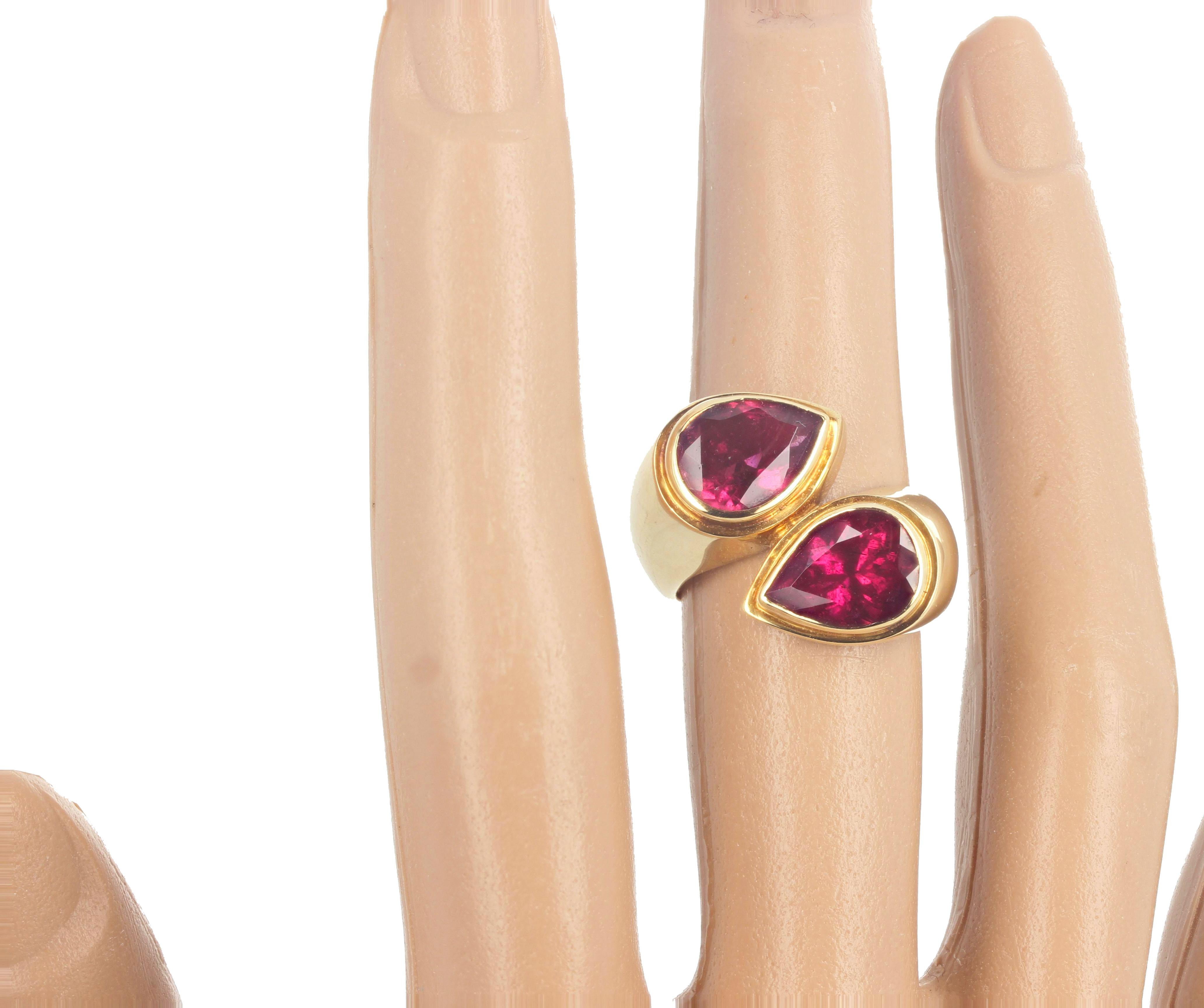 These two pear cut sparkling intense red Rubelite Tourmalines (approximately 2.5 carats each) are set in 18Kt thick yellow gold ring size 7 (sizable for free).  This ring is a throwback to the elegance and glamour of the 1960's Italian movie stars. 