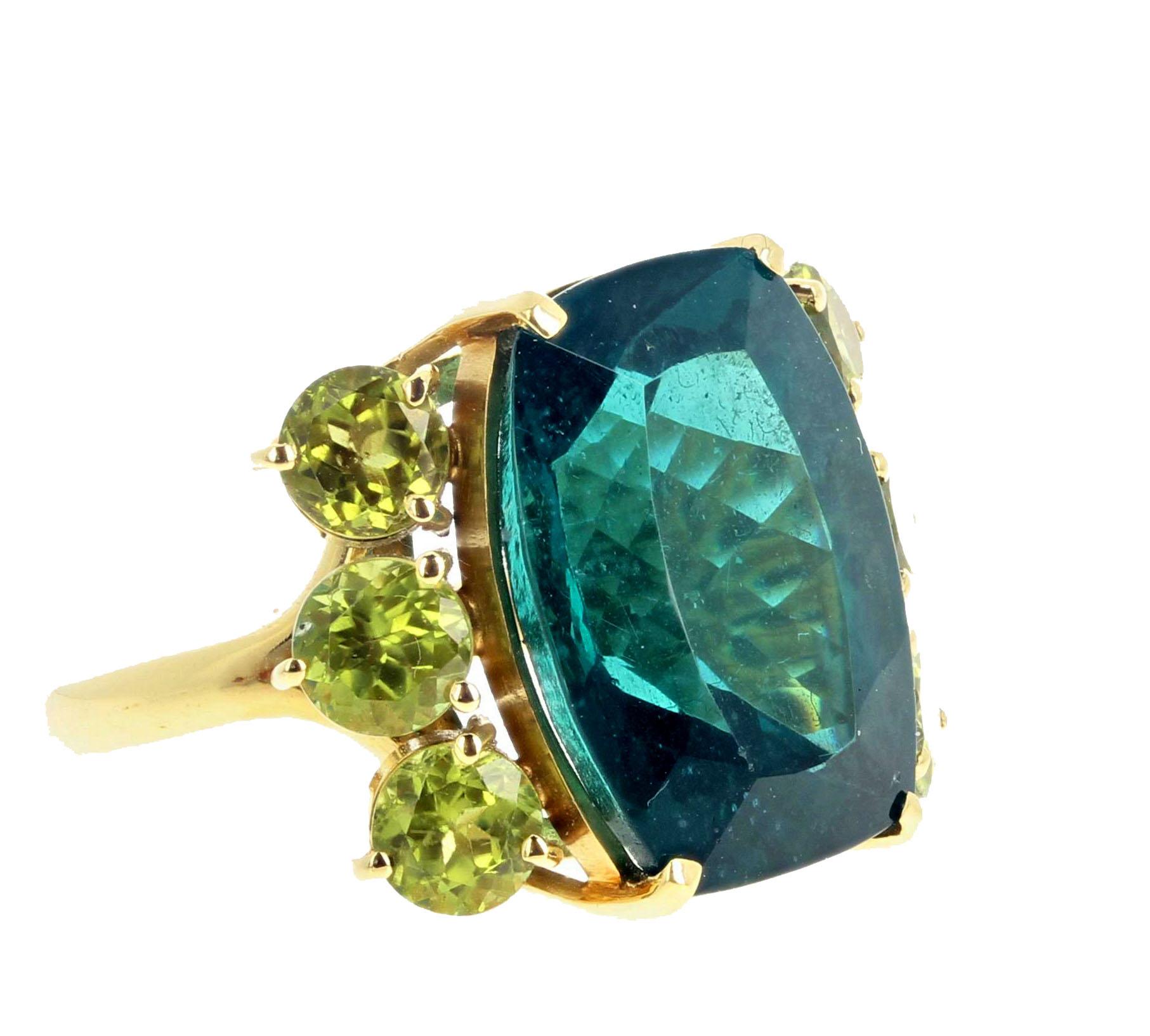 Exquisite rare and very large 18.8 Carat natural blue Indicolite Tourmaline enhanced with 6 glittering natural Peridots (0.30 carats each) set in 18Kt yellow gold ring size 7 (sizable). There are no eye visible inclusions in this gorgeous