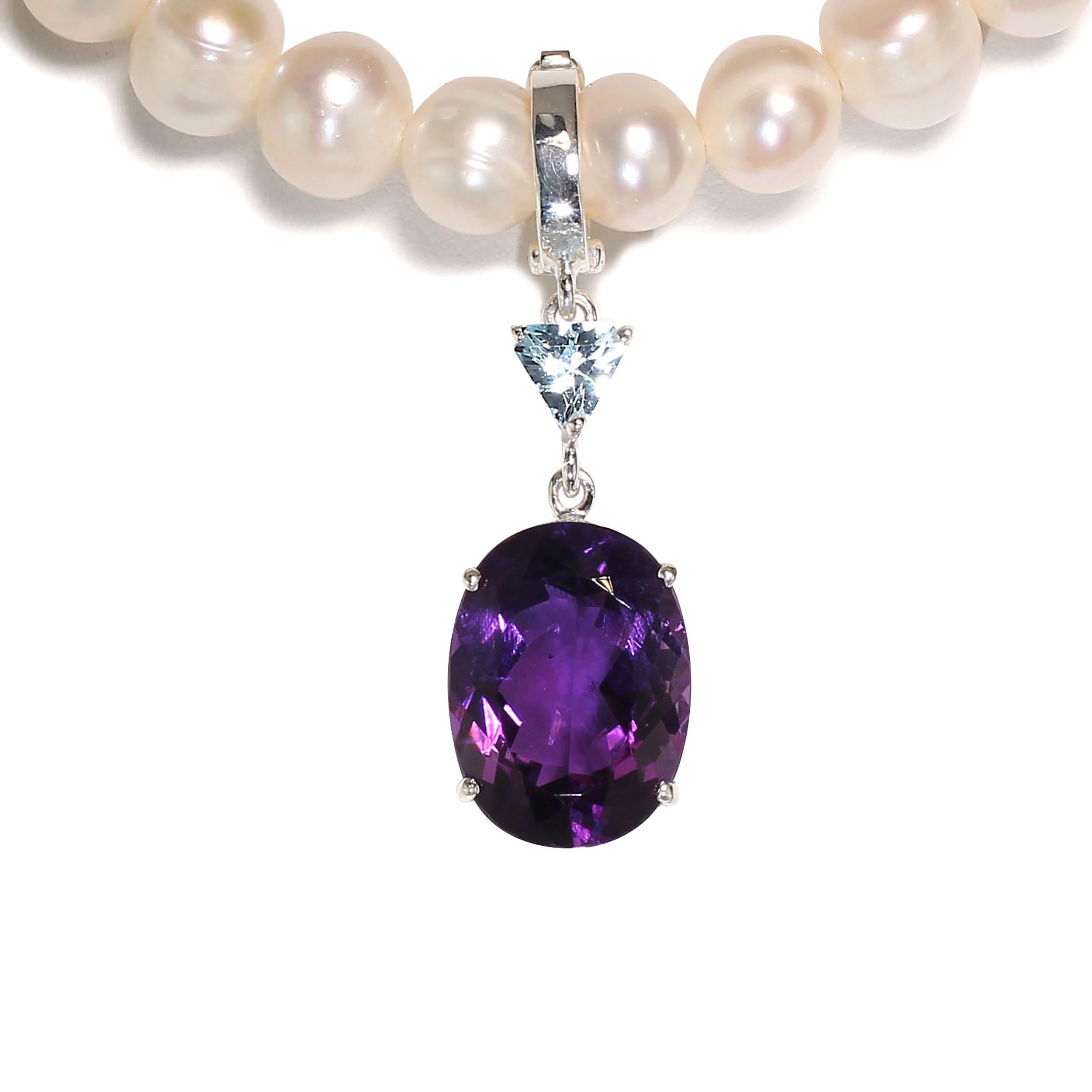 Elegant pendant of sparkling oval Amethyst with an accent of Blue Topaz set in hand made Sterling Silver.  This lovely pendant is so versatile you'll find yourself hooking it onto all your pearls, necklaces, and chain with its hinged bail.  At 1.5