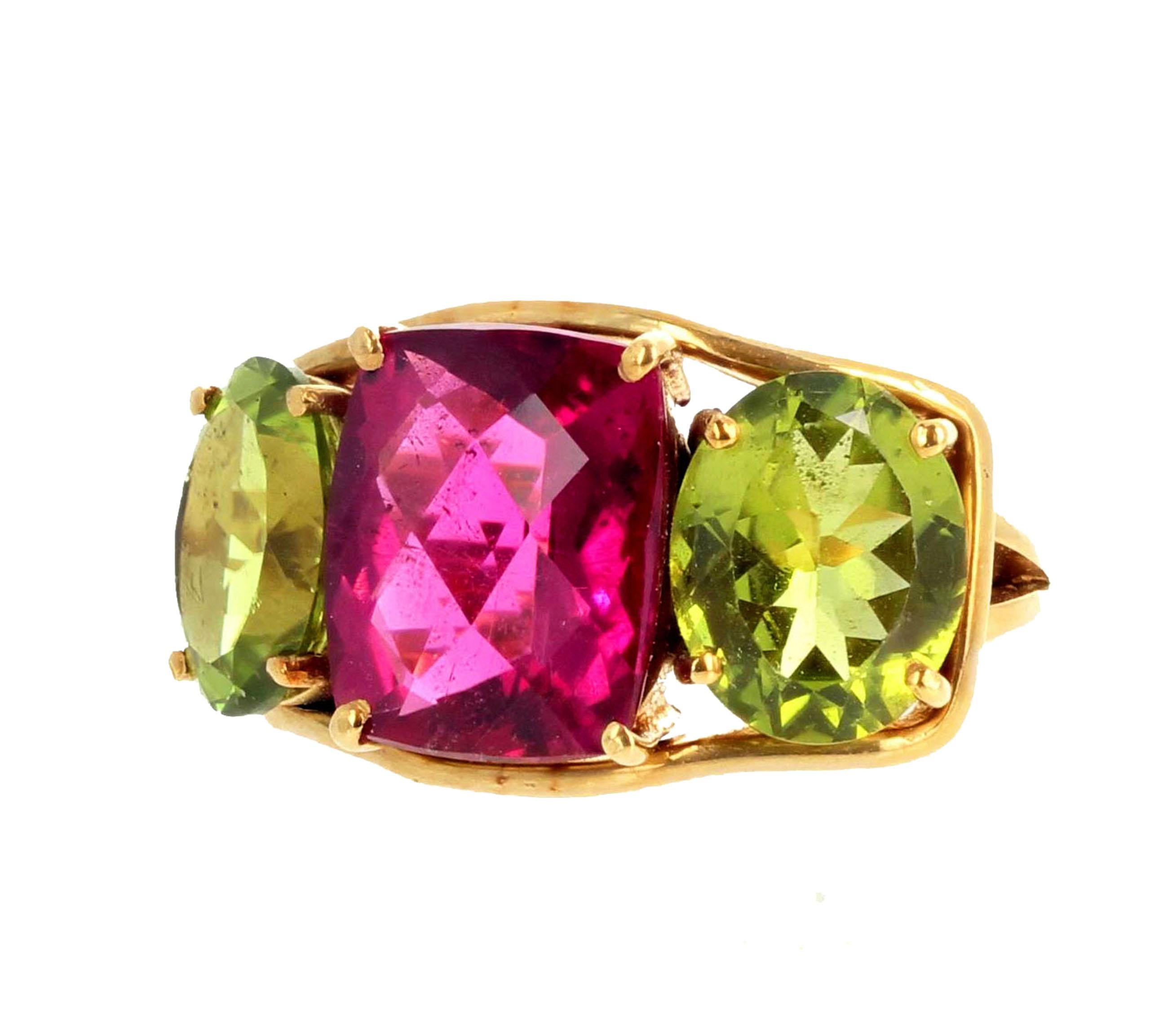 Glittering brilliant intense pinkyred natural Rubelite Tourmaline enhanced on each side with glittering oval green natural Peridots set in 18Kt yellow gold ring size 7 (sizable for free).  The earrings are 9.45 carats of Peridot enhanced with tiny