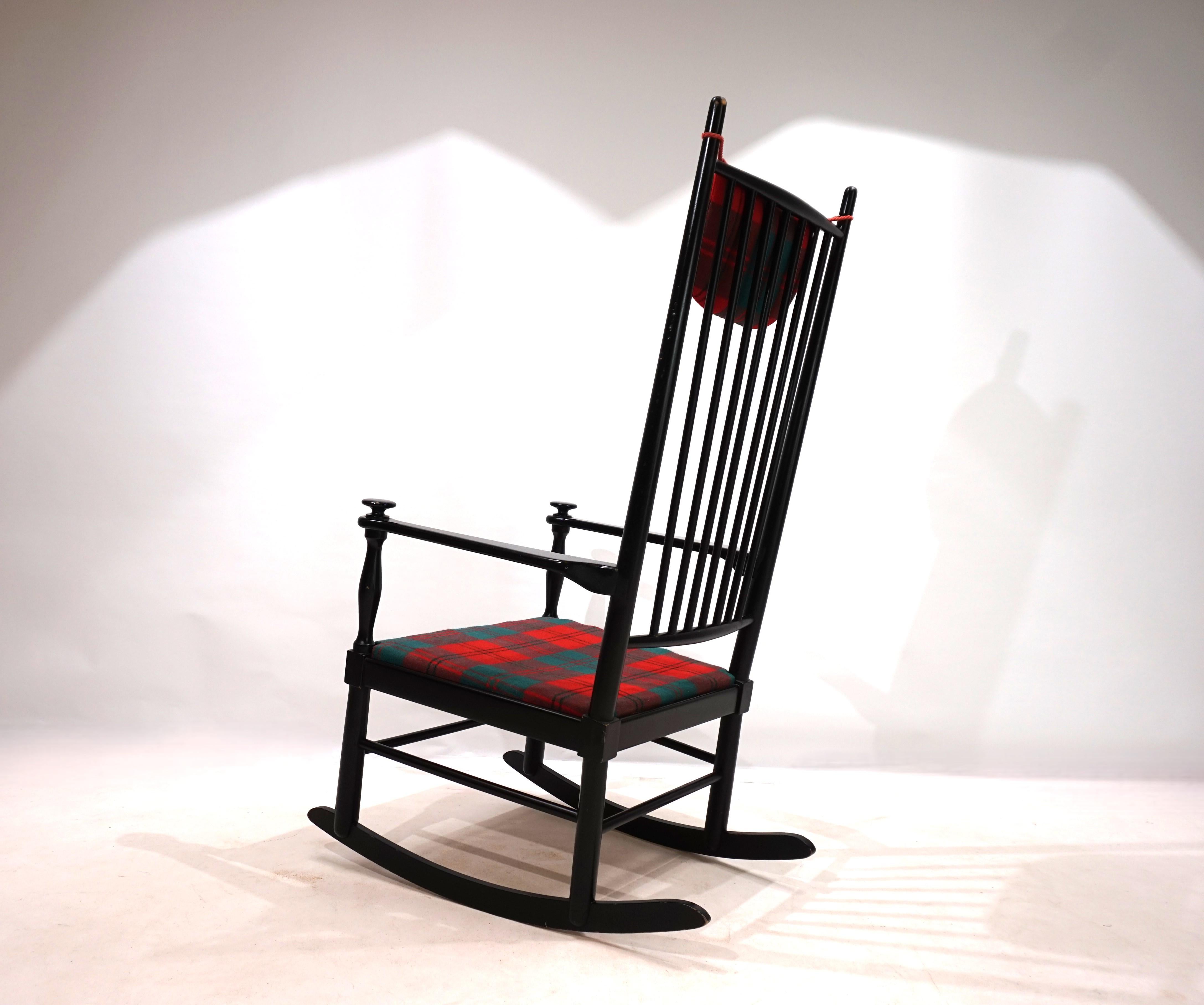 Una sedia a dondolo Isabella laccata di nero e con un rivestimento in tessuto a quadri perfettamente abbinato per i cuscini della seduta e della testa. La cornice in legno è in ottime condizioni, con lievi segni di usura sugli angoli delle guide e