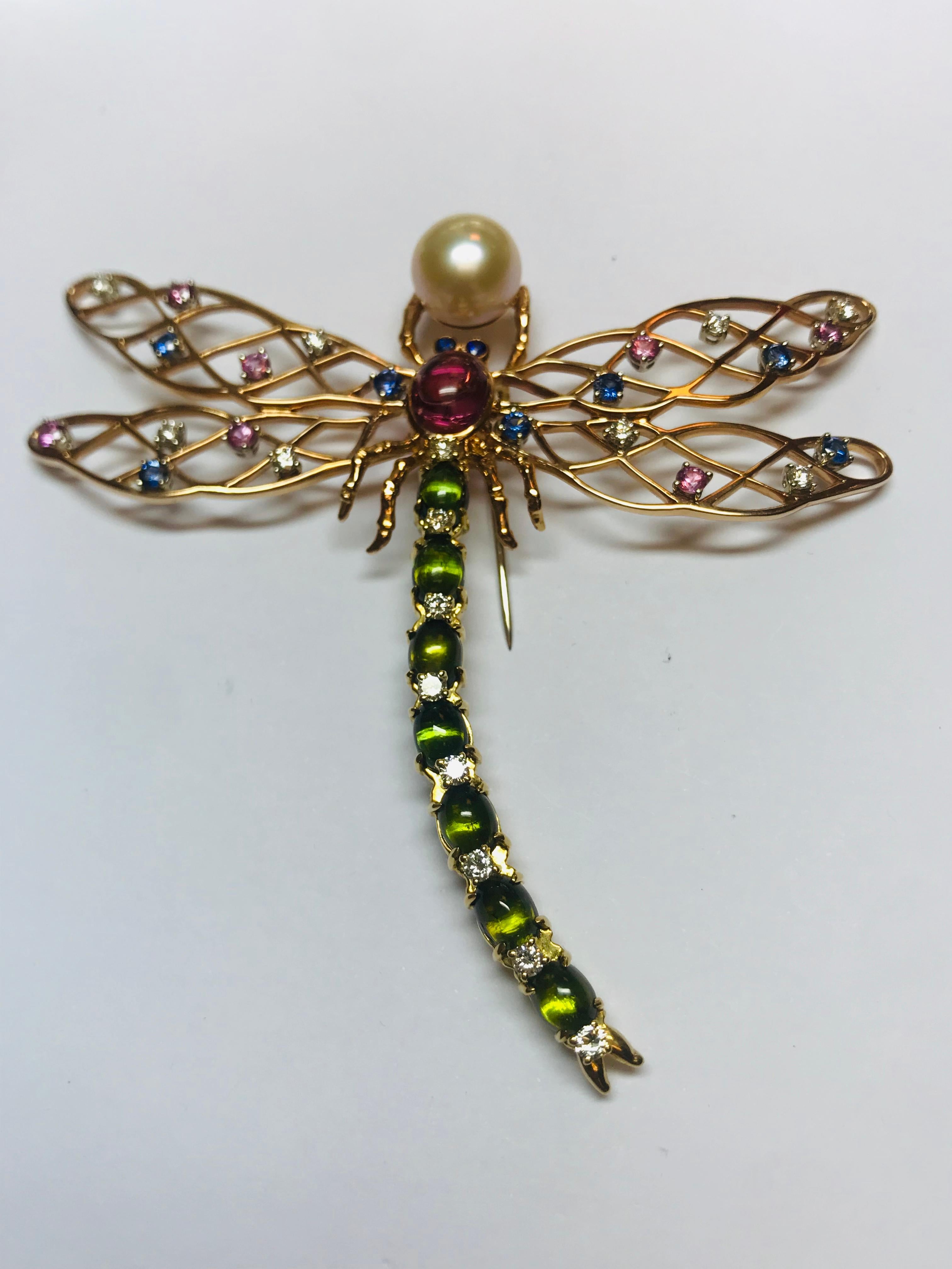 This Dragonfly brooch is a one off creation with spectacular detail. The combination of 7 cabochon cut gem quality Green Tourmalines in the tail and a large Pink Tourmaline in the center along with 1.17 carats of diamonds and .93 carats each of Pink