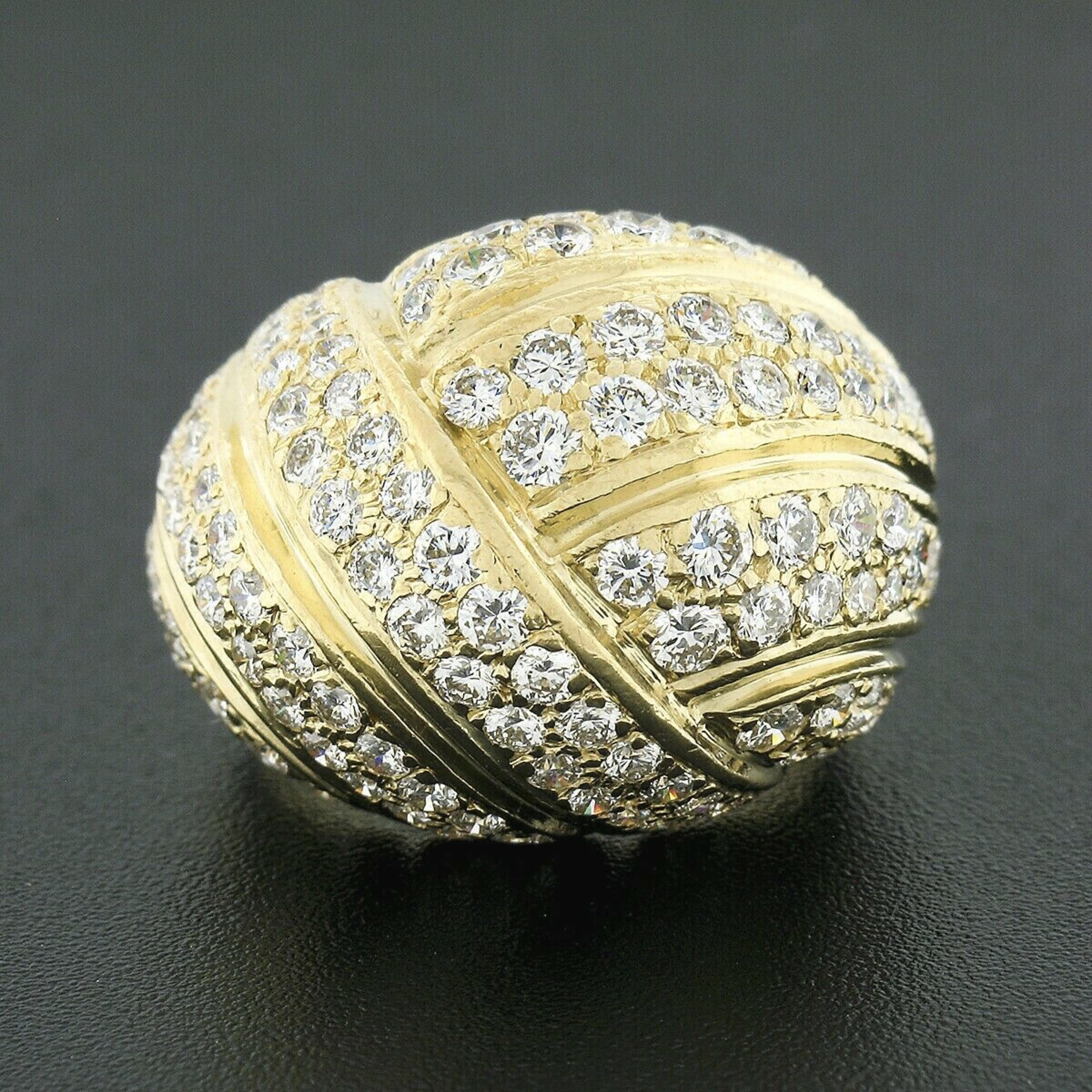 This breathtaking and bold bombe style ring was crafted in solid 18k yellow gold and designed by Gemlok. Its domed top features an absolutely elegant, grooved and overlapping design that is drenched with TOP QUALITY diamonds throughout. These round