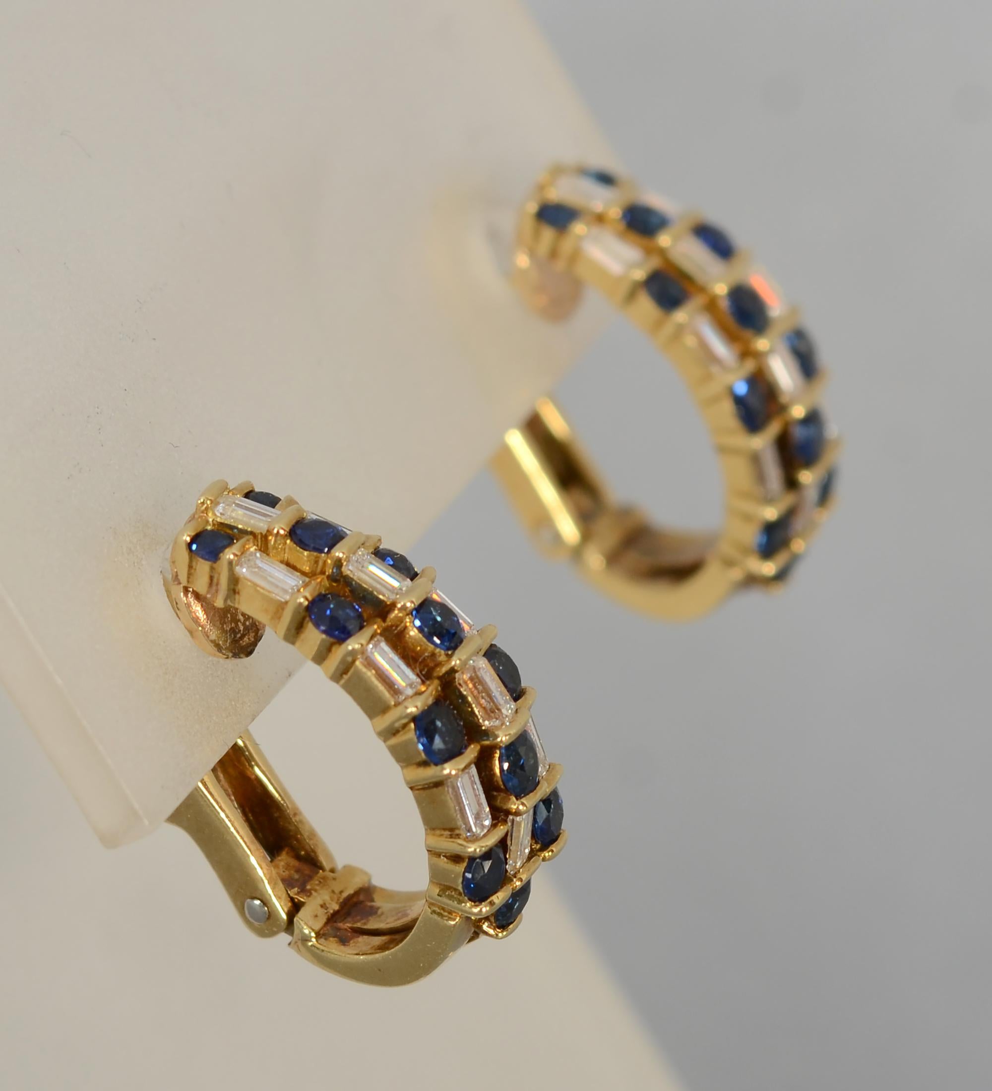 Finely made half hoop earrings by Gemlok with alternating baguette diamonds and round sapphires. Omega backs are hinged with posts. The earrings are 3/4