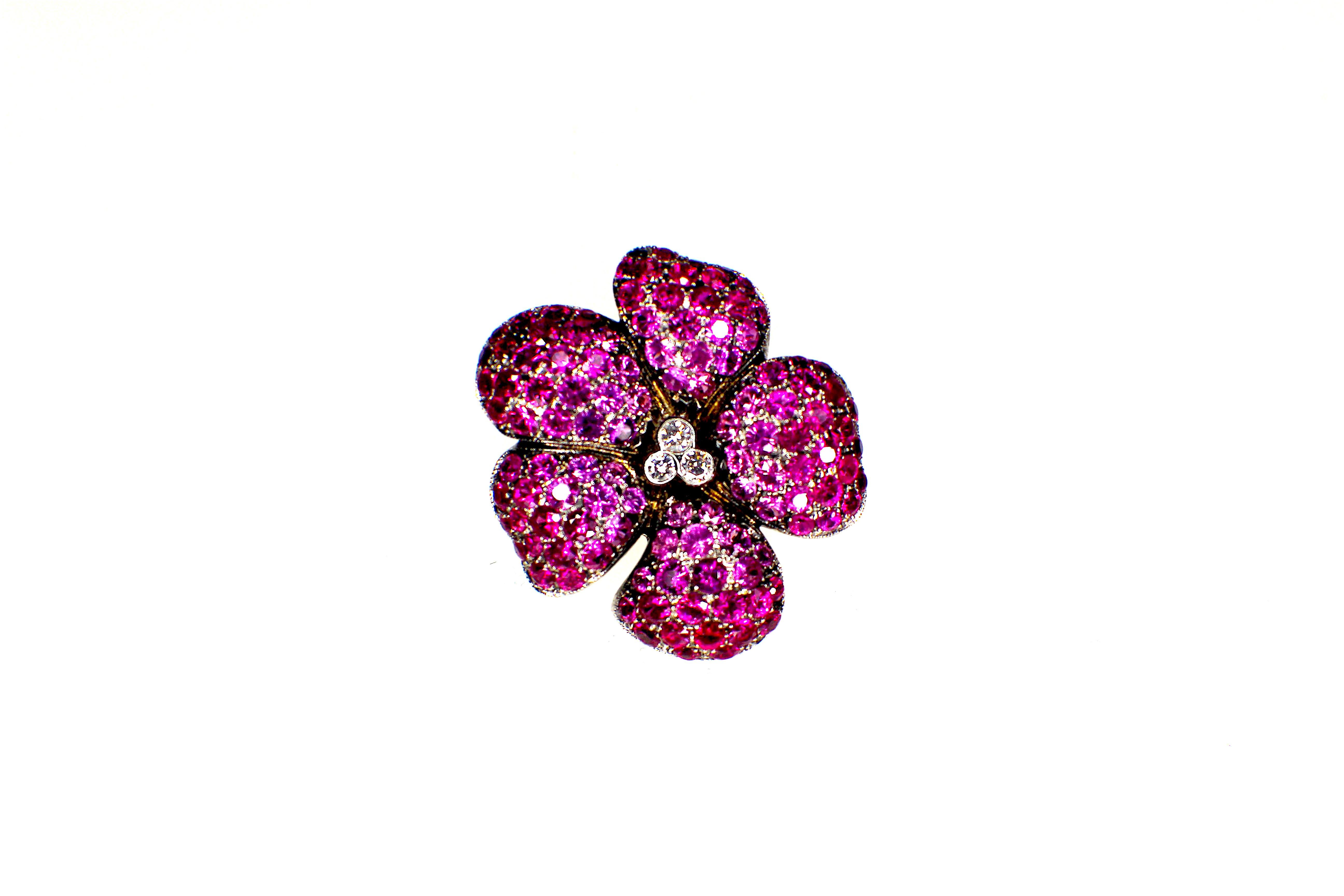 GEMOLITHOS Ruby, pink sapphire and diamond Brooch - 18 Karat Gold, 
Diam.: 0.20 ct G/VS 
Ruby-Pink Sapphires : circa 8.0ct very clean No inclusions visible.  nice color transaction in total. 
Size: 2.9 cm diameter. 