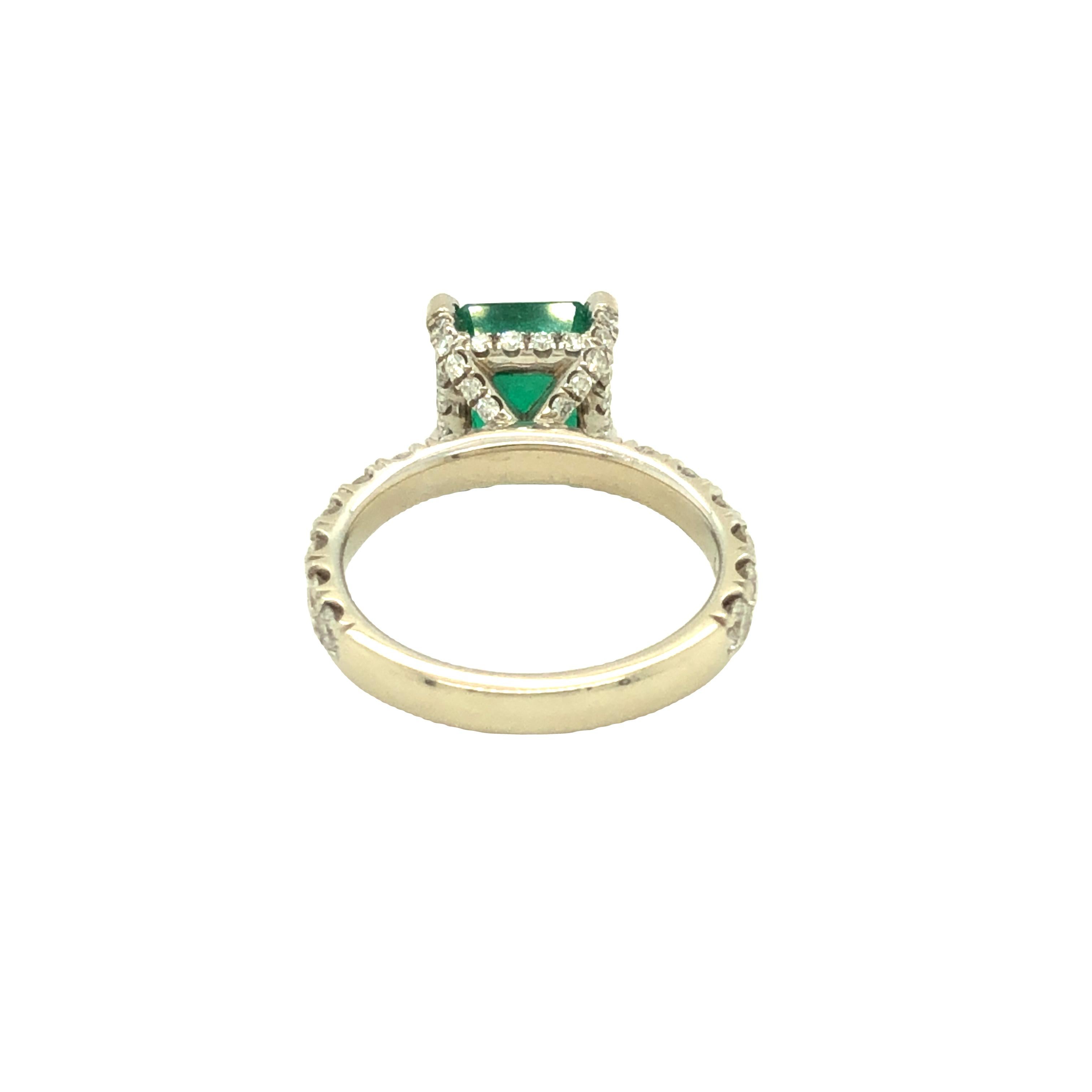 Stunning 2.30 carat vivid green emerald is set in 14K white gold ring embellished with colorless diamonds on prongs, basket, and ring band. The diamonds weighs 1.72 carat total, F-G color and VS clarity. We hand selected this beautiful natural