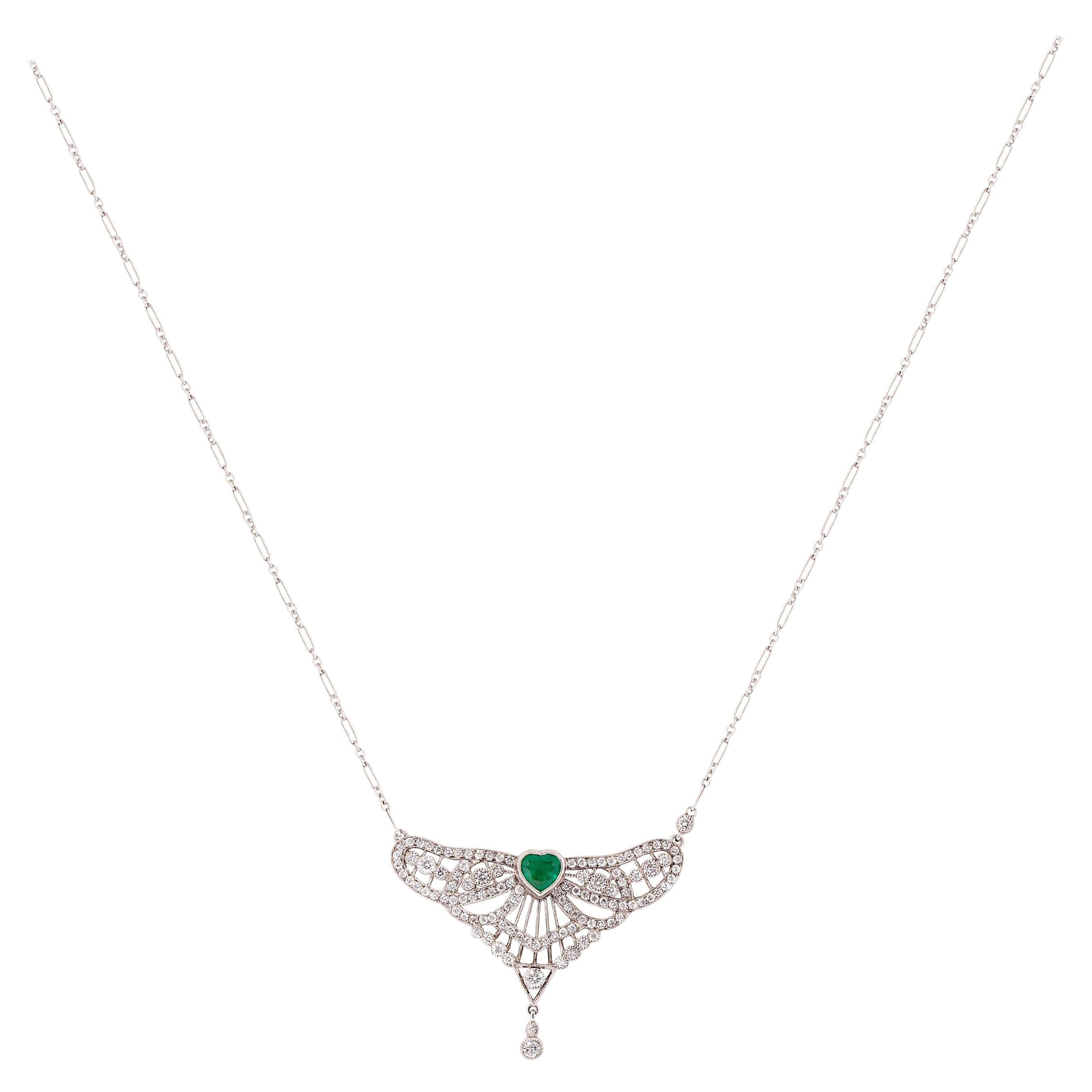 Inspiriert von den schönen Linien und der Symmetrie der Art Deco Ära, zentriert dieser Anhänger einen 0,81 Karat schweren, herzförmigen Smaragd. Der tiefgrüne Smaragd wird durch 112 runde Brillanten mit einem Gesamtgewicht von 1,44 Karat und