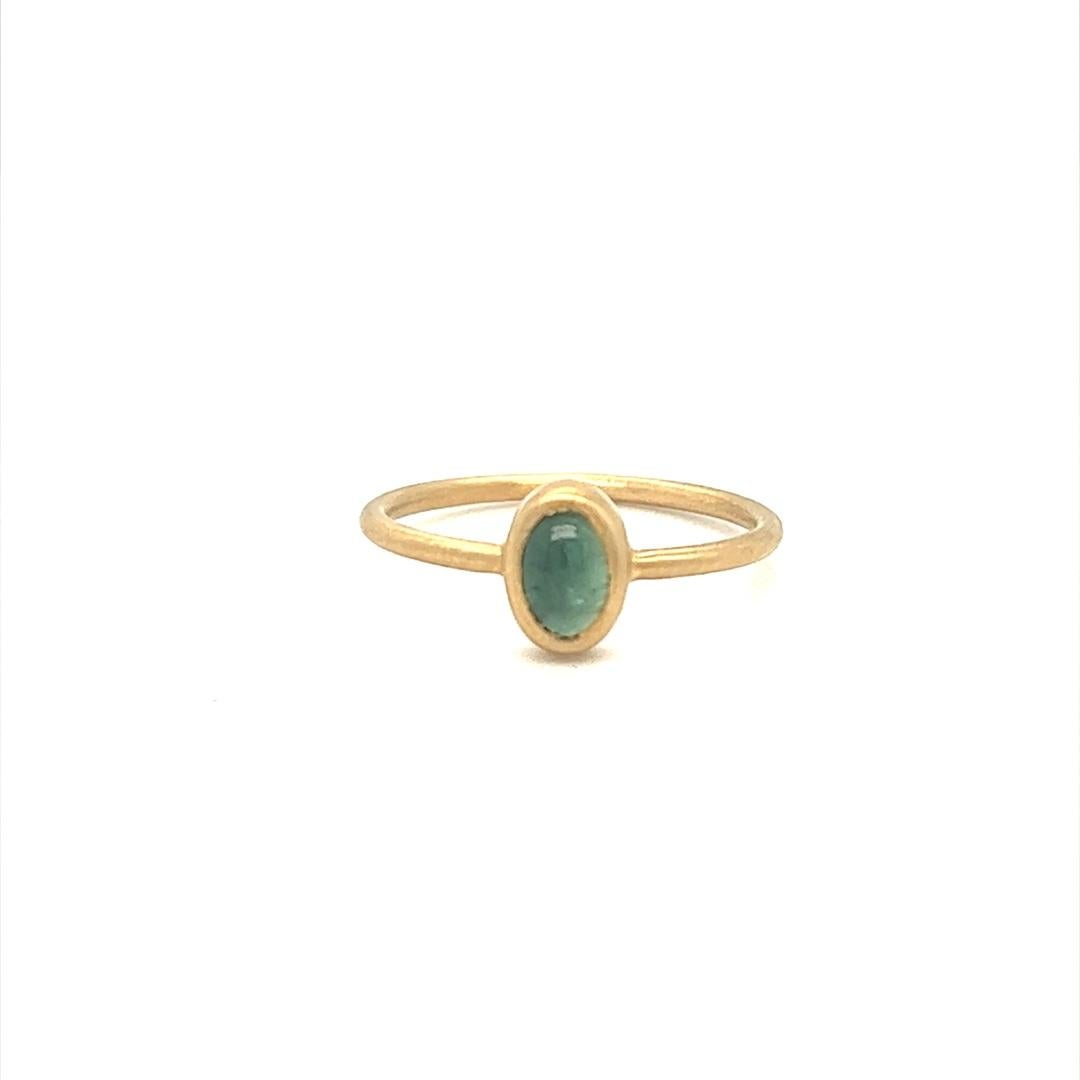 Designed and crafted by Gems Are Forever in Beverly Hills, CA, this modern classic ring features a cabochon green tourmaline set in 14K yellow gold bezel setting brushed gold. The tourmaline weighs 0.37 carat. The ring is in size 6 and can be