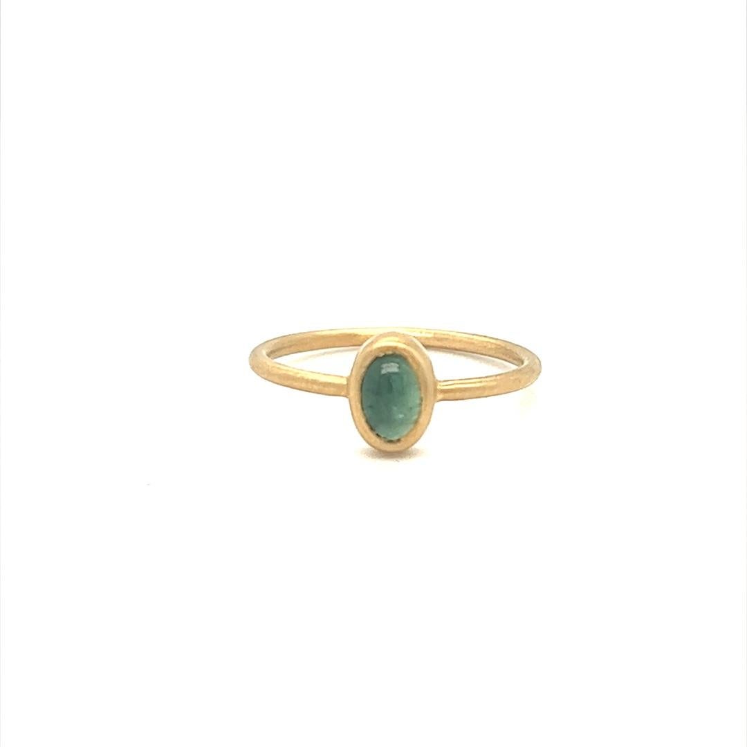 Progettato e realizzato da Gems Are Forever a Beverly Hills, CA, questo anello classico moderno presenta una tormalina verde cabochon incastonata in un castone d'oro giallo 14 carati spazzolato. La tormalina pesa 0,37 carati. L'anello è di misura 6