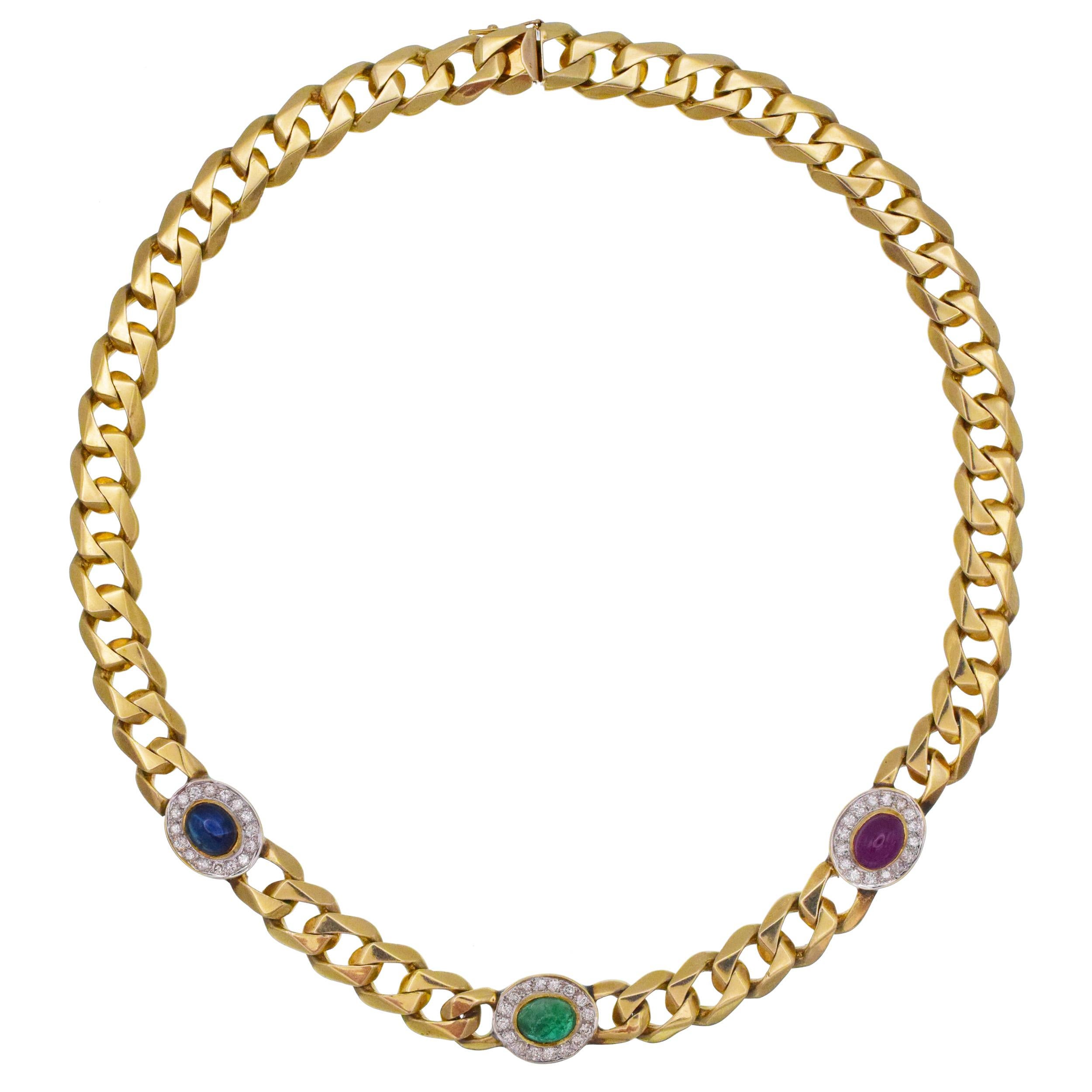 Gemstone and diamond cuban link necklace crafted in 14k yellow gold. The necklace features 51 curb links. Front of the necklace is accented with 3 oval shaped, gem and diamond links. There is one cabochon cut sapphire, one cabochon cut emerald
and