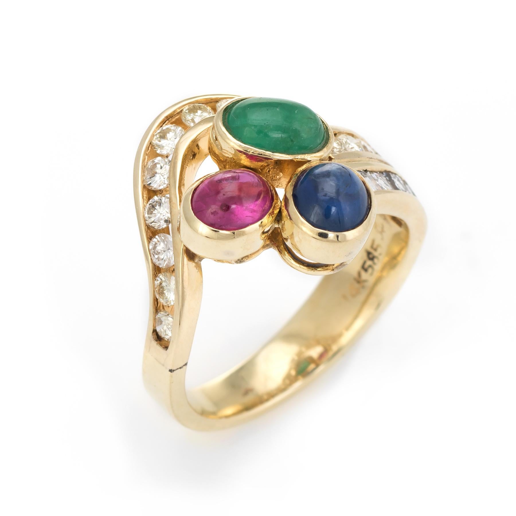 Finely detailed gemstone cluster ring, crafted in 14 karat yellow gold. 

Cabochon cut emerald measures 6mm x 4mm, ruby measures 5mm x 4mm and the sapphire measures 5.5mm x 4.5mm. The gemstones total an estimated 1 carat. The mixed cut emerald and