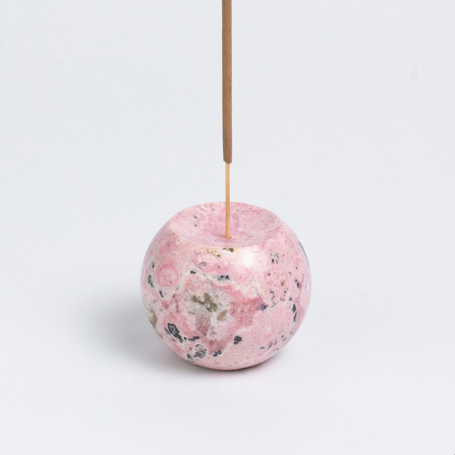 Deleita a un entusiasta de las piedras con un porta-incienso único en su especie: el Porta-incienso Esfera Rosa de Rodonita. Elaborada con auténticas piedras semipreciosas, infunde a cualquier decoración una energía tranquilizadora y un toque de