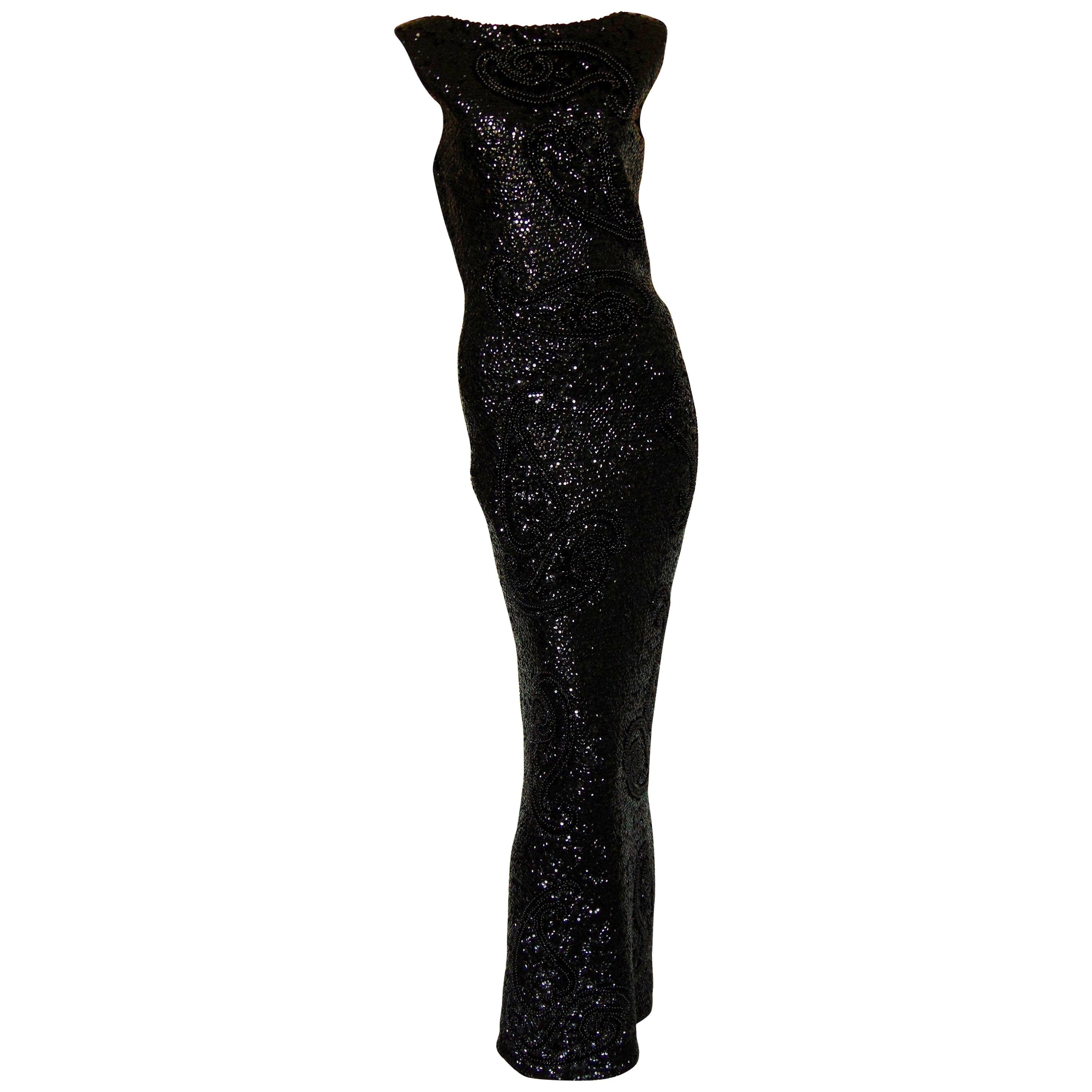 This incredible evening gown was designed by Gene Shelly Boutique Internationale, most likely in the early 1960s. Made from stretchy soft wool, this piece features hand sewn jet beads and black sequins throughout, making it sparkle and shimmer as