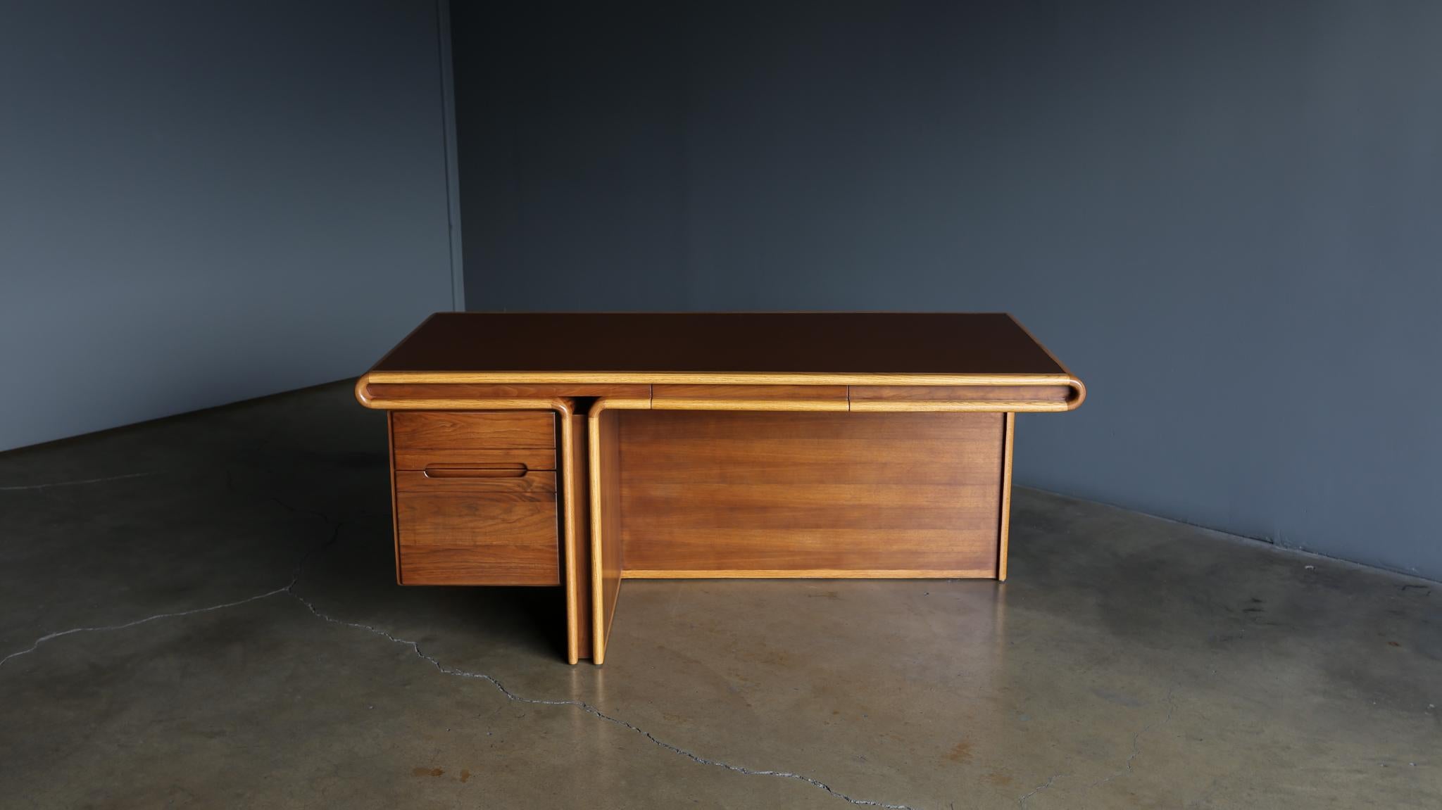 Generation 80 oak and walnut desk with a leather top. Circa 1980. This piece has been expertly restored.