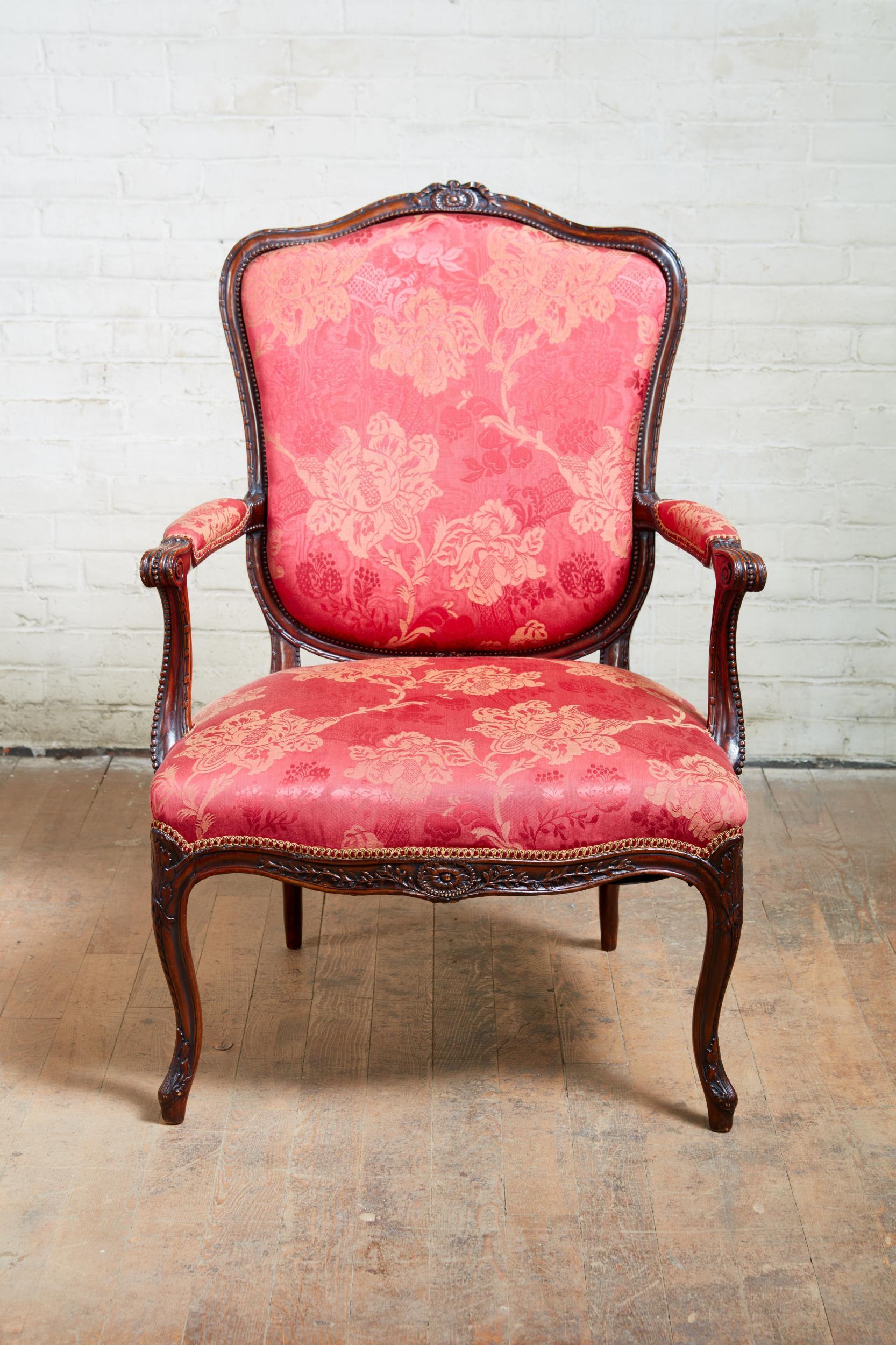 Very fine and overscale George III armchair in the manner of John Linnell, having shaped back with paterae and ribbon carved crest, over a removable upholstered panel, the frame with edges of ribbon tied ribbing and beading, the scrolled arms