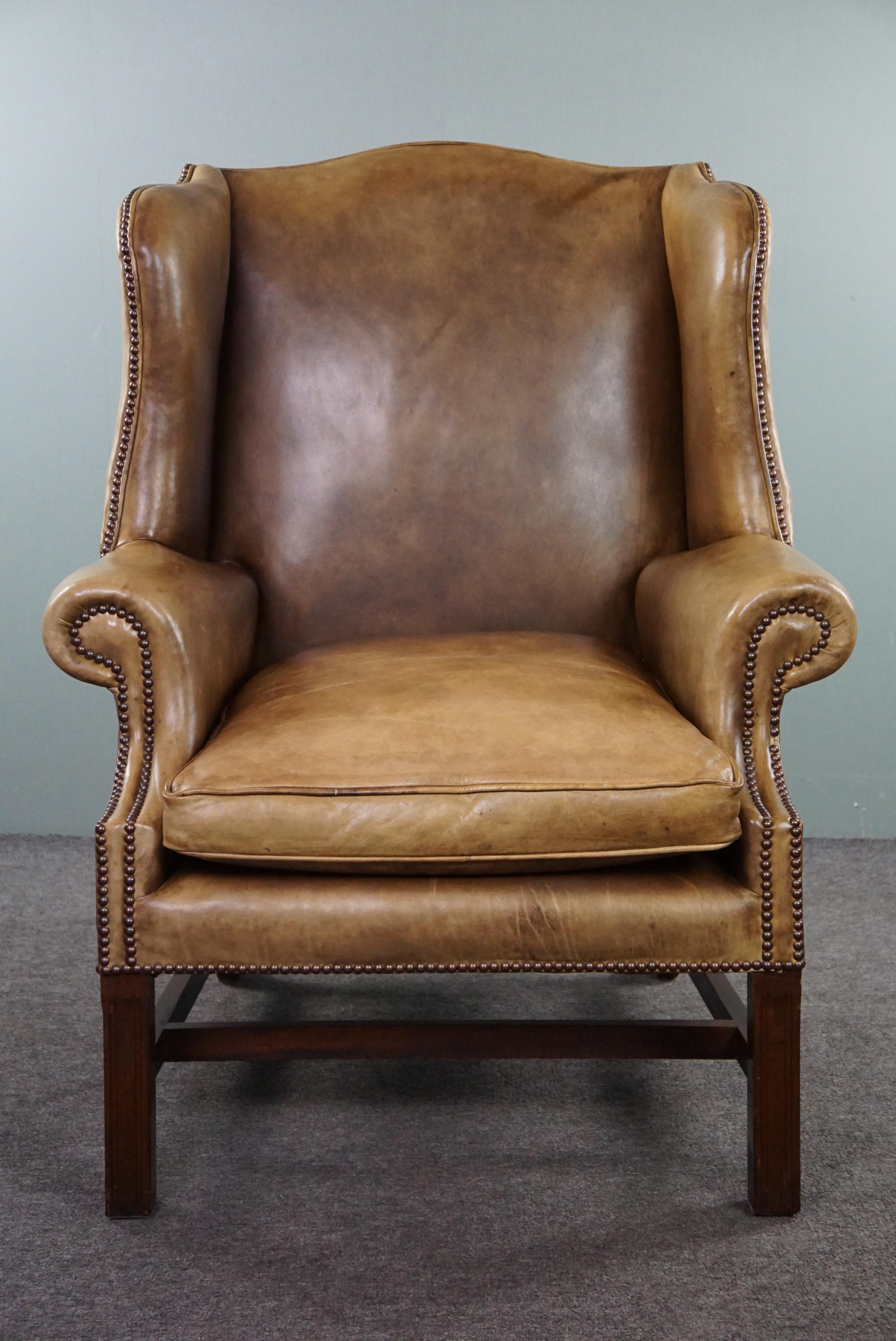 Offered this comfortable leather wingback armchair. If you're looking for an elegant wingback chair made of cowhide, then this extremely comfortable blonde leather wingback armchair might be the perfect choice for you. This armchair combines style