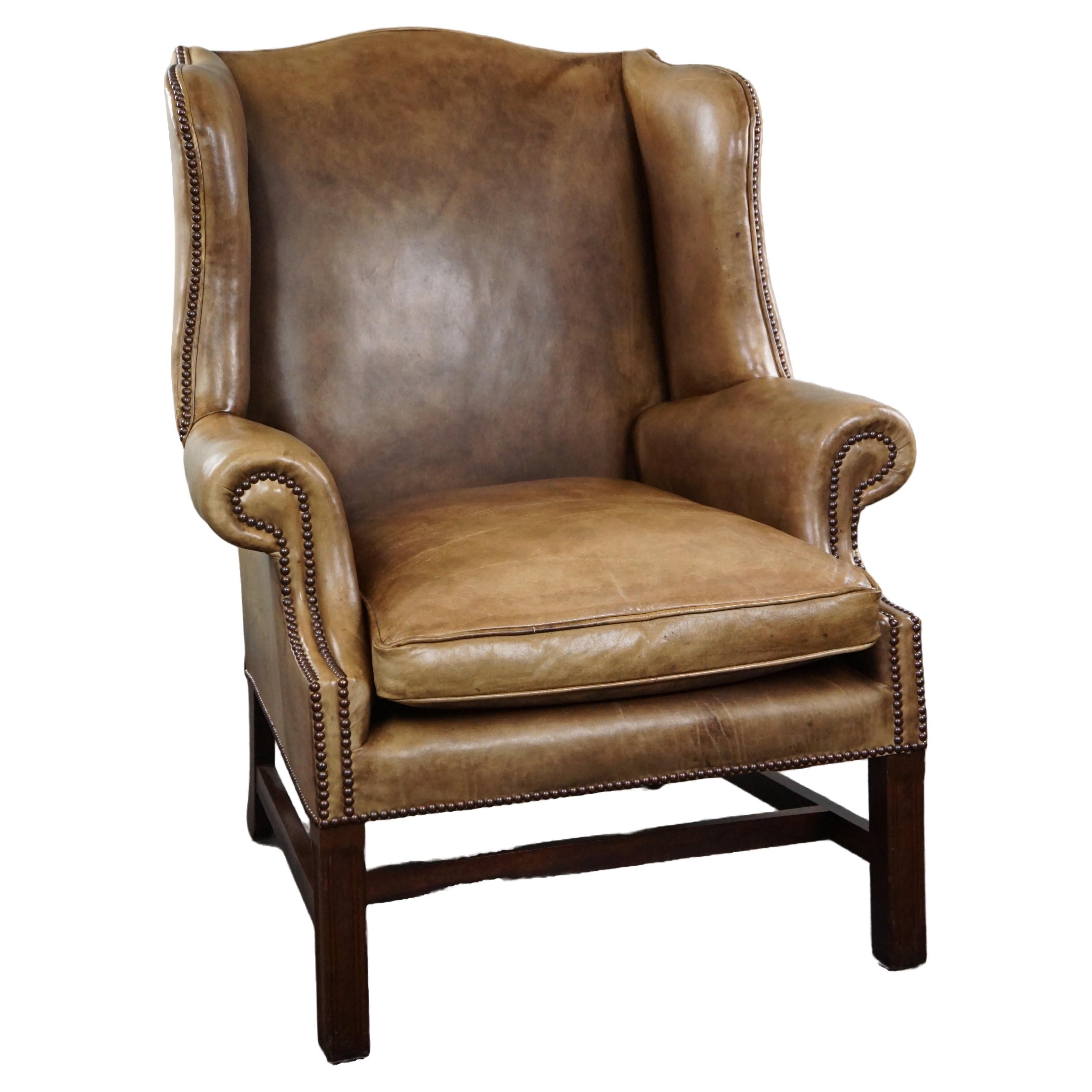Generous leather wingback armchair in very good condition.  For Sale