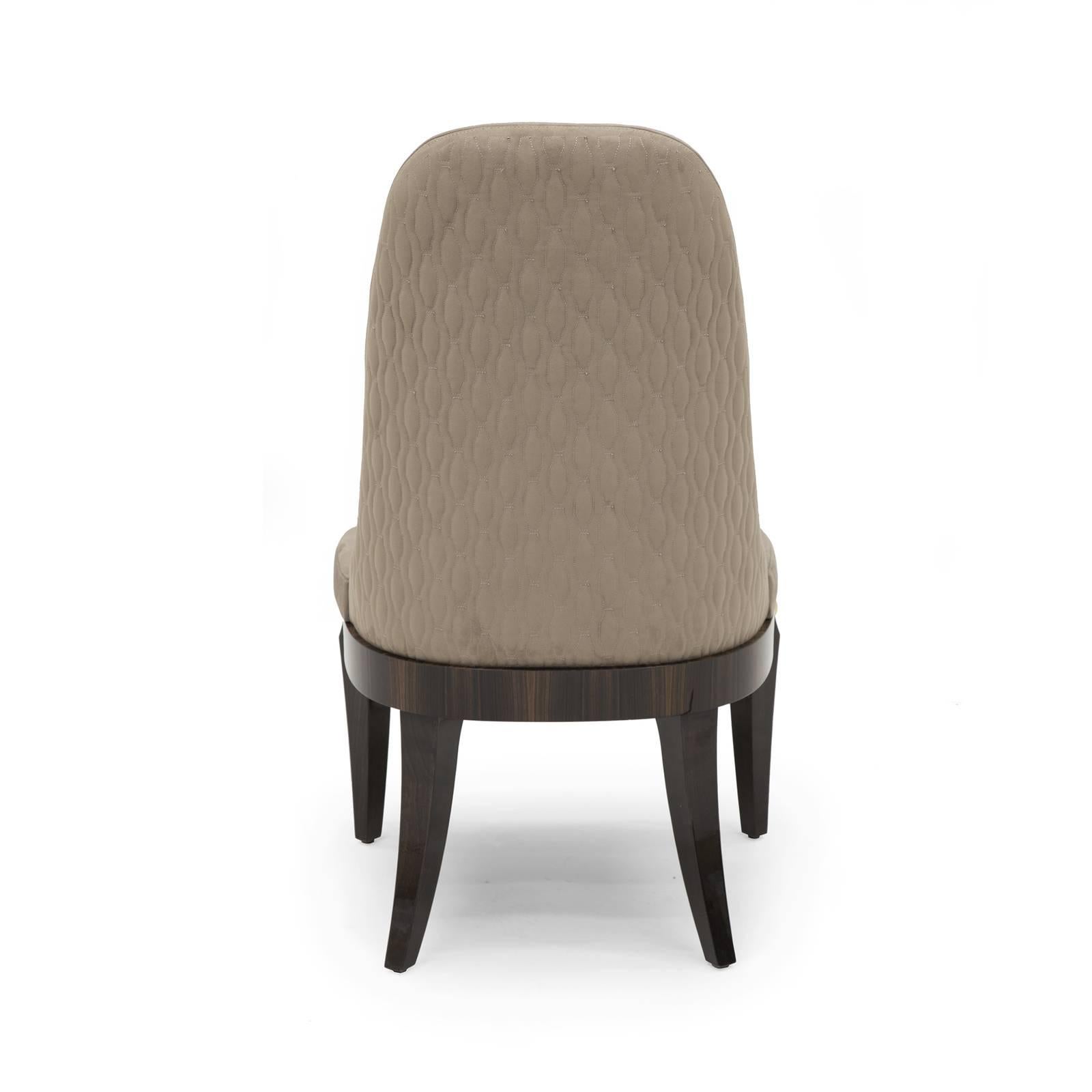 Distinguished for its effortless silhouette, this chair will be a sublime accent around any dining room table. The seat is crafted of veneered ebony and has a round shape with squared front embellished with vertical inlays of gold-plated metal. The