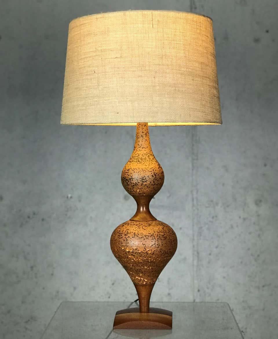 Excellent 1950s genie lamp made of ceramic and walnut. Maker unknown, though it is handcrafted and nicely done. The contrasting materials and blended colors provide a copper hue to the wonderful curves on this lamp. Rewired.

Lamp measures: 7