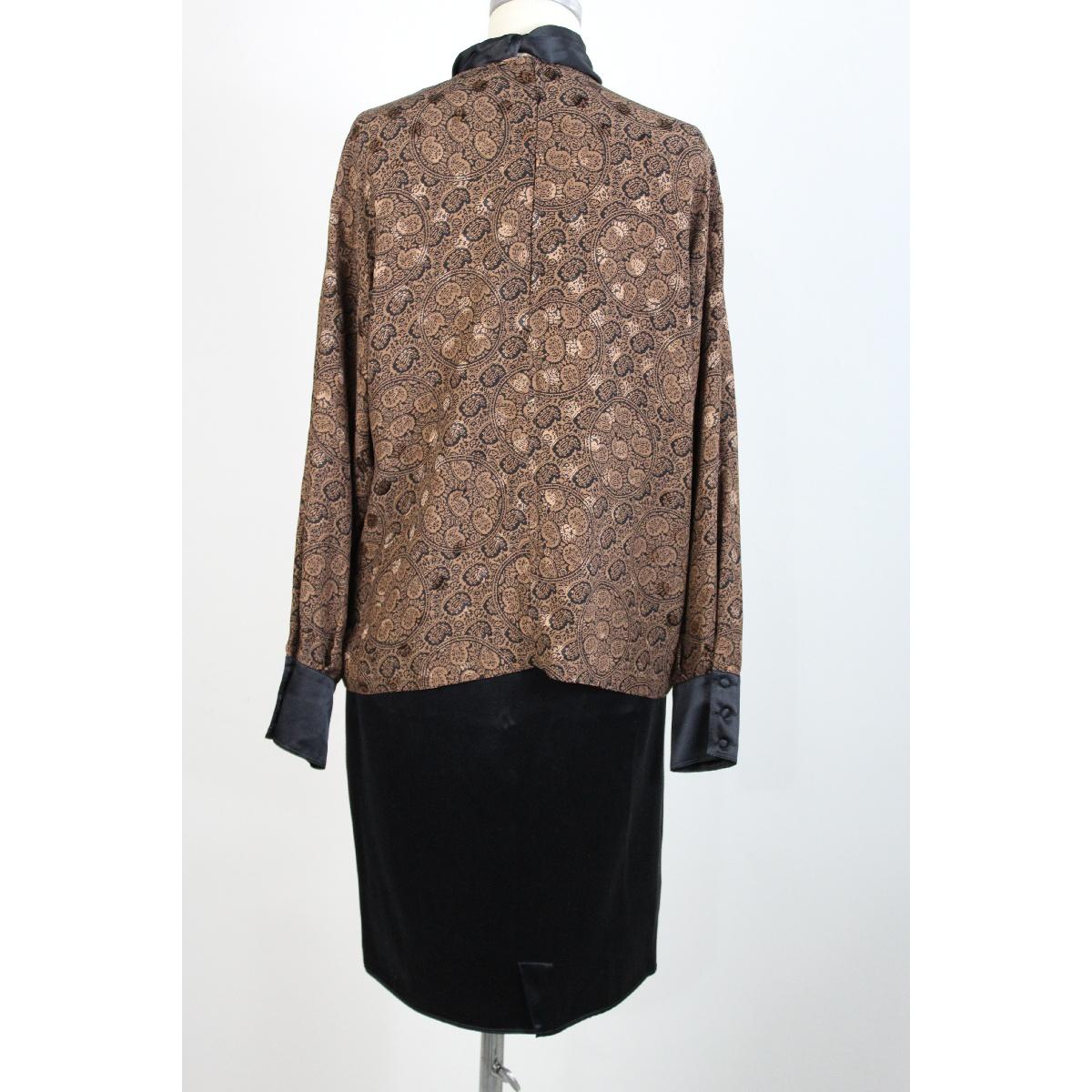Genny 80s vintage evening skirt suit. Soft blouse with high collar and sash, brown color with paisley designs, black sheath model skirt. 100% silk fabric. Made in Italy.

Size 44 IT; 10 Us; 12 UK

Shoulder: 44 cm
Bust/chest: 58 cm
Sleeve: 60