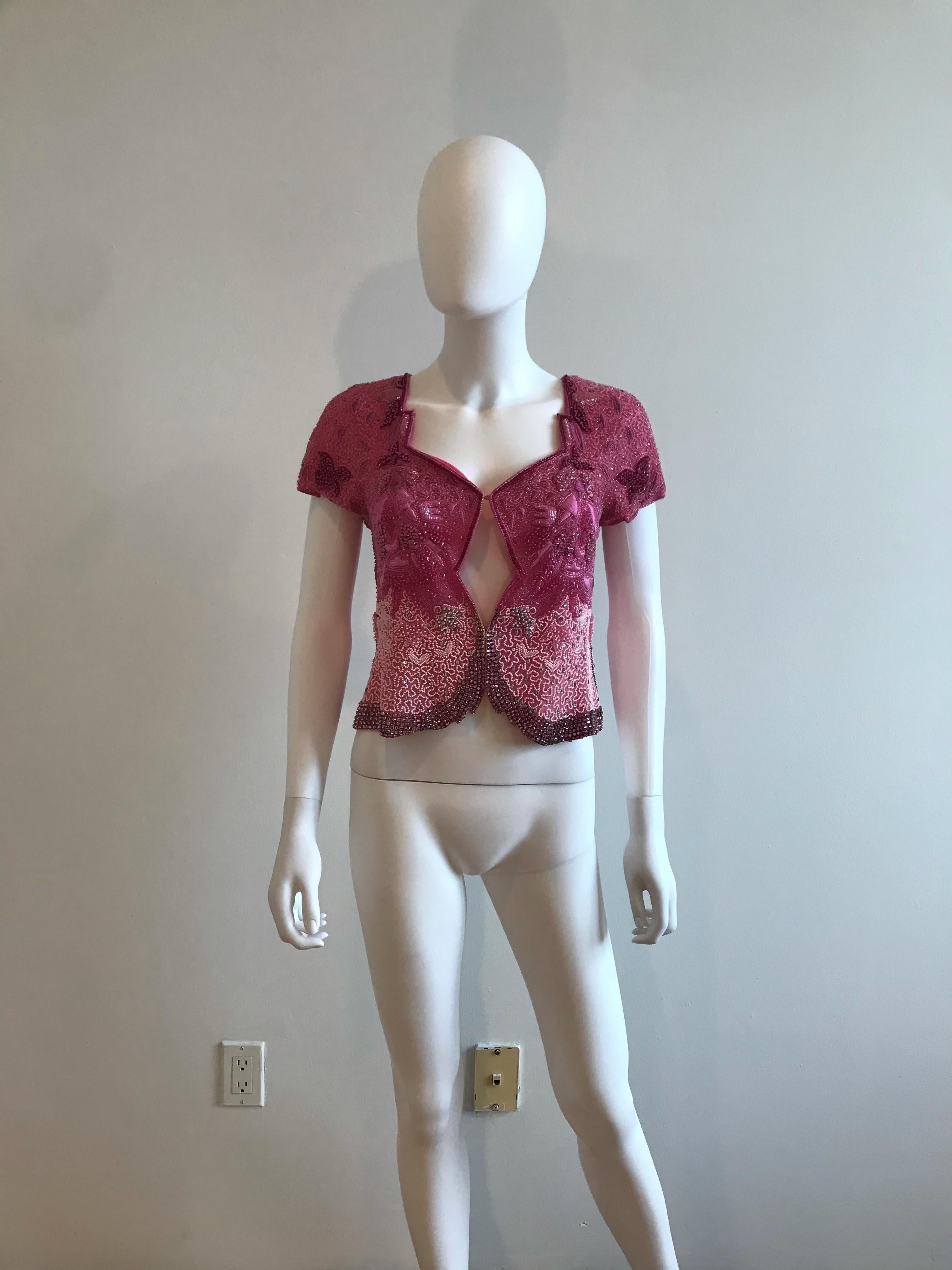 This rare and glamorous Genny by Gianni Versace Pink Bolero features beaded diamond embroidery. It is short sleeved.
Designer Label Removed. Size US 10