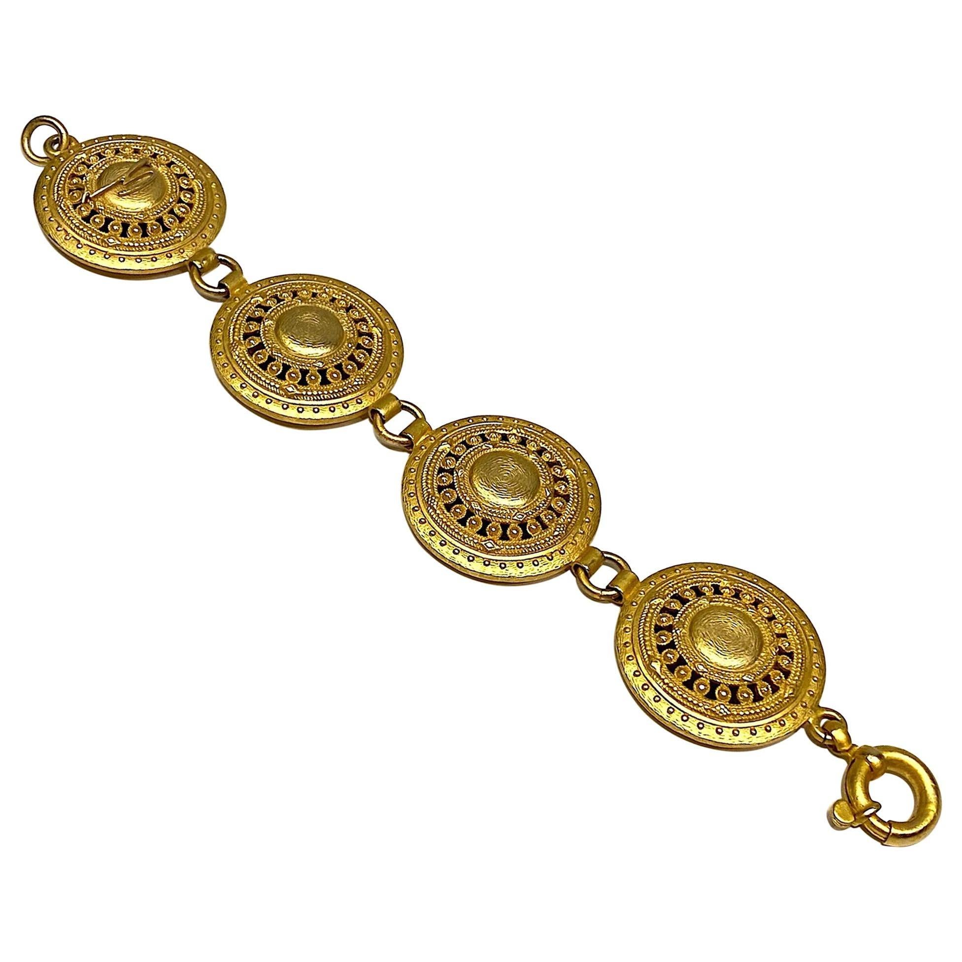 A wonderful ancient Etruscan inspired bracelet by Italian fashion house Genny circa 1990. The bracelet is comprised of four large 1.38 inch diameter pierced and bead work design lightly domed disks. They are attached by .32 of an inch small round
