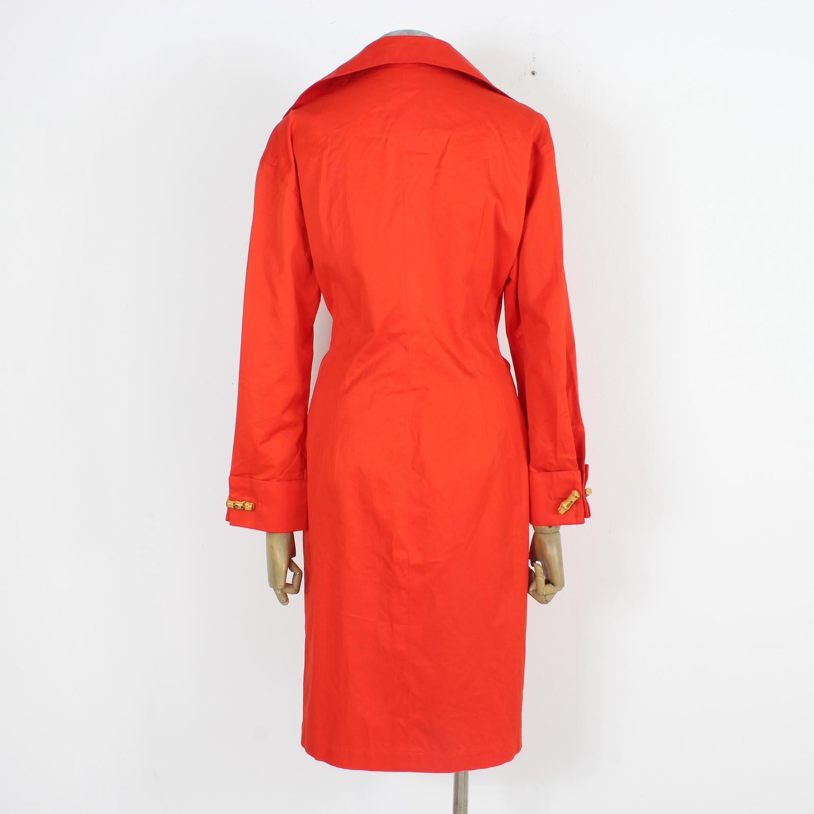 Genny elegantes Vintage-Kleid aus den 90ern. Rote Farbe, Verschluss mit speziellen Froschknöpfen aus Holz. Tiefer V-Ausschnitt, der in der Taille mit einer verstellbaren Schleife geschlossen wird. Lange Ärmel mit zwei Holzfroschknöpfen. stoff aus