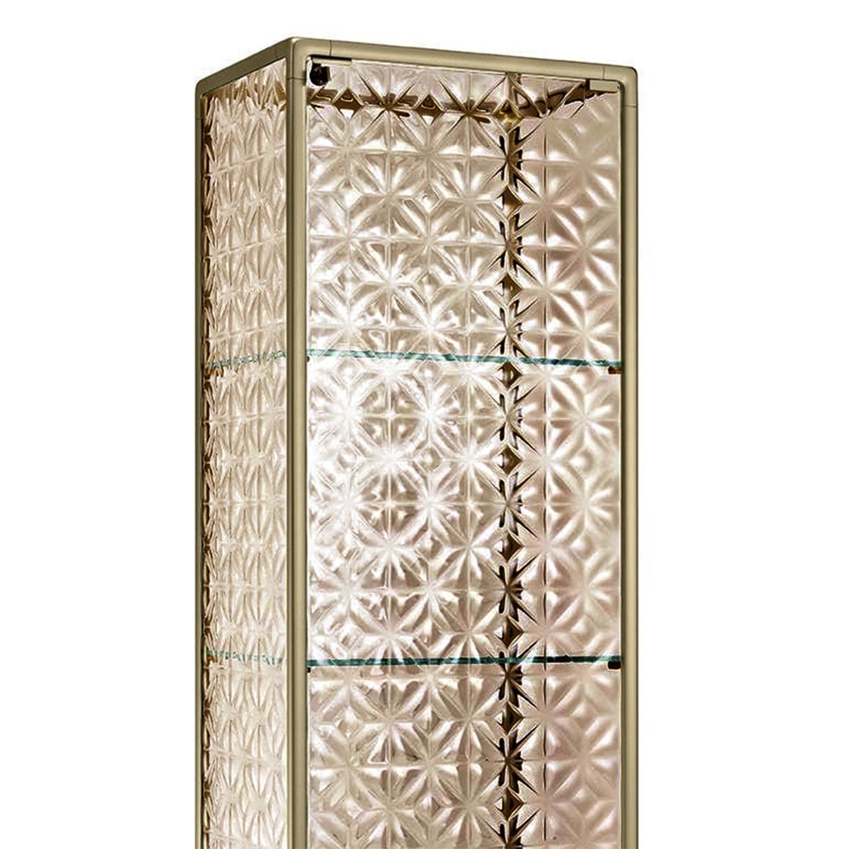 Glass Case Genova Medium with aluminum structure
in veneered brass finish. With fused carved bronzed glass
structure and doors, 6mm thickness. Inside tempered 
glass shelves in 8mm thickness. Each shelf can support 
20 kilos. Base in tempered