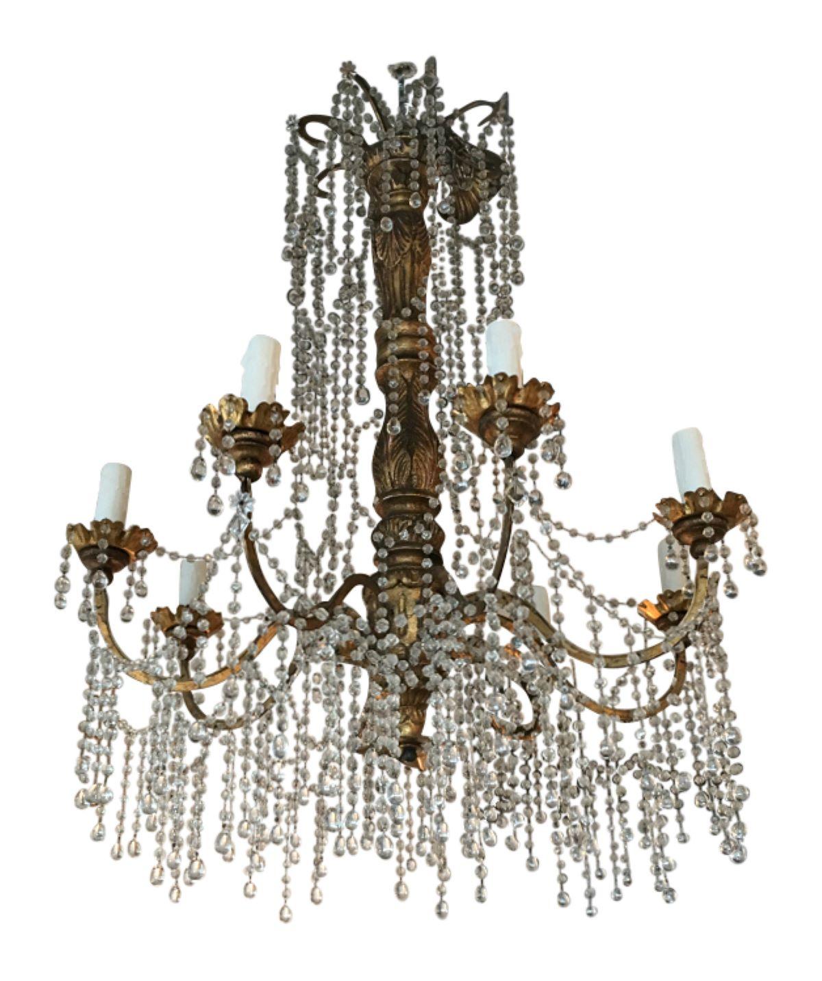 Genovese giltwood chandelier from the early 1900's. Stunning craftsmanship with delicate crystals strung throughout the giltwood base. This chandelier screams elegance and is truly a timeless investment.