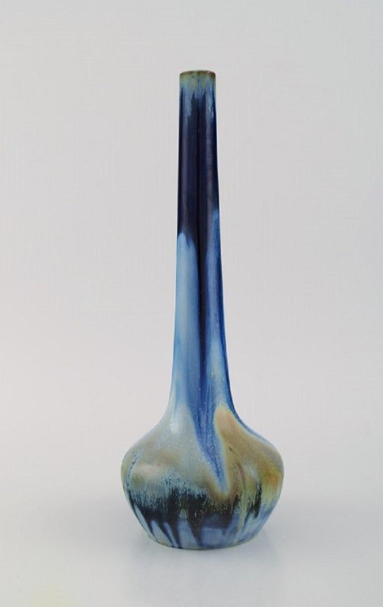 Gentil Sourdet, France. Long necked vase in glazed stoneware. Beautiful glaze in shades of blue and green. 
Mid-20th century.
Measures: 28.5 x 10.5 cm.
In excellent condition.
Signed.