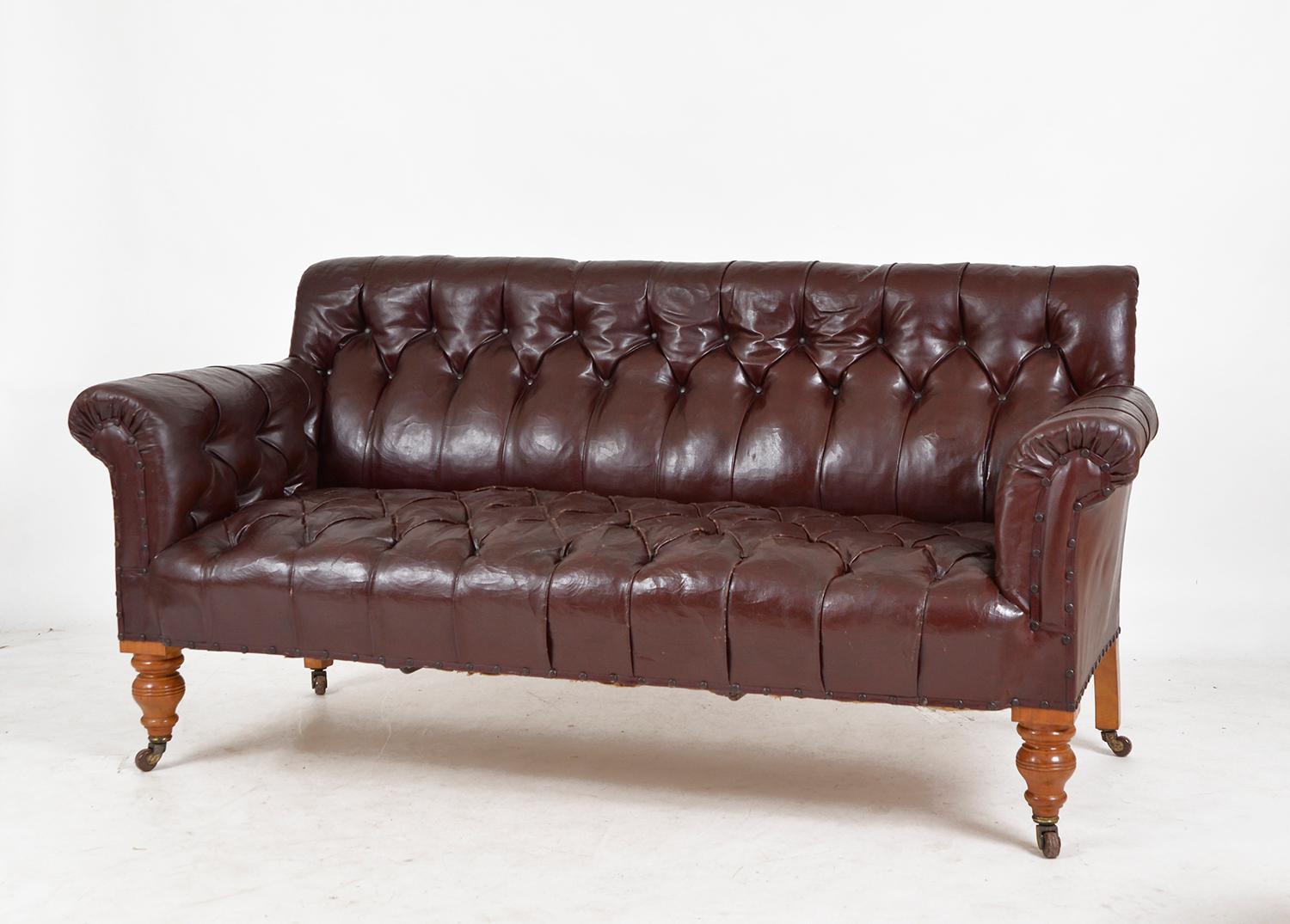 A wonderful 19th century Gentleman’s library settee sourced from a country house estate in Scotland. In the original buttoned leather cloth with brass head tack detailing, in an attractive oxblood colour, on turned birch legs with porcelain castors.