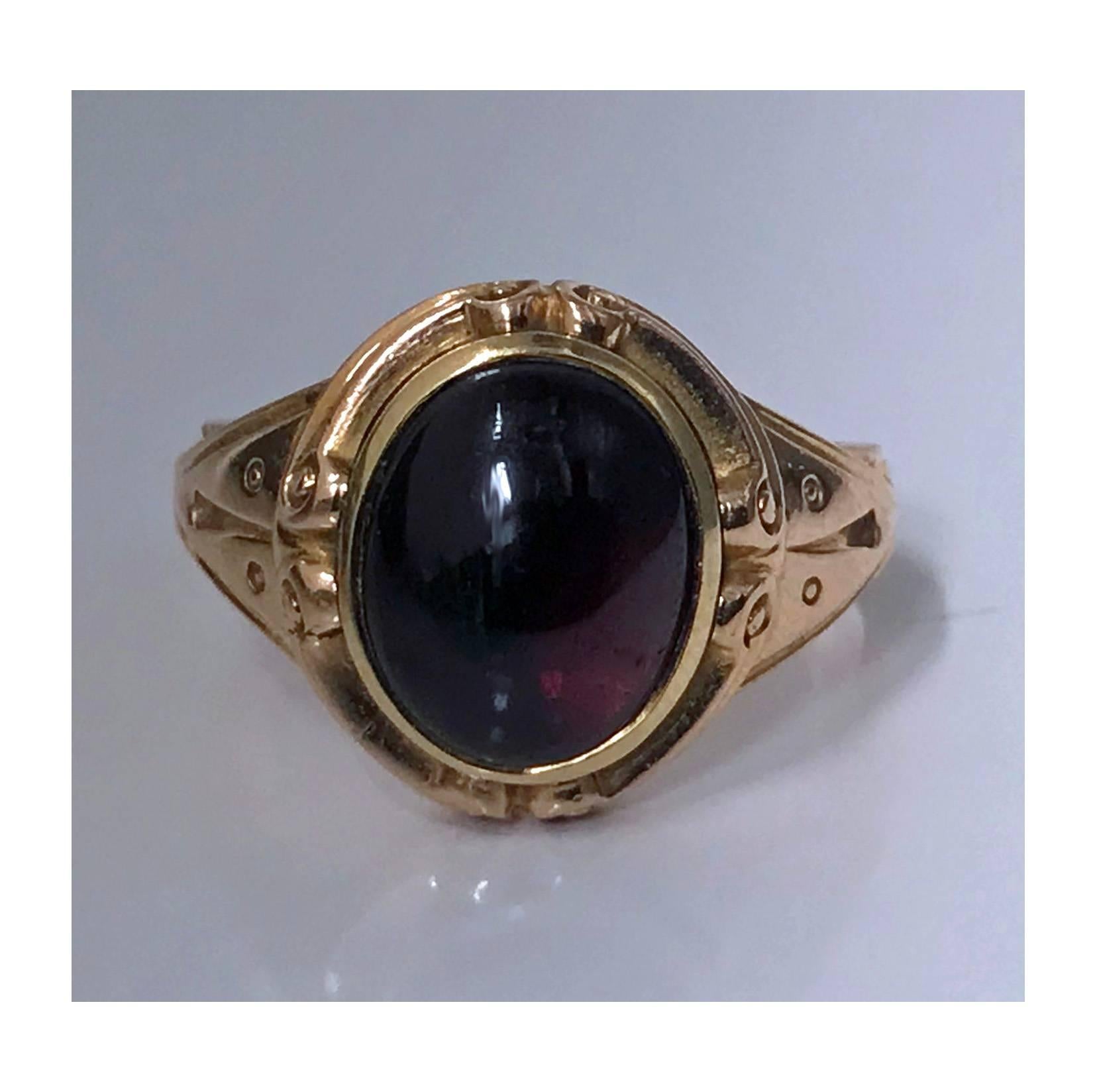 Fine Antique 19th century 14K rose gold ring with a deep red garnet cabochon or carbuncle, gauging 12.5 x 10.0 mm in a closed-back setting with carved surround mount and shoulders. Stamped 14K on interior of shank. Item Weight: 10.34 grams. Ring