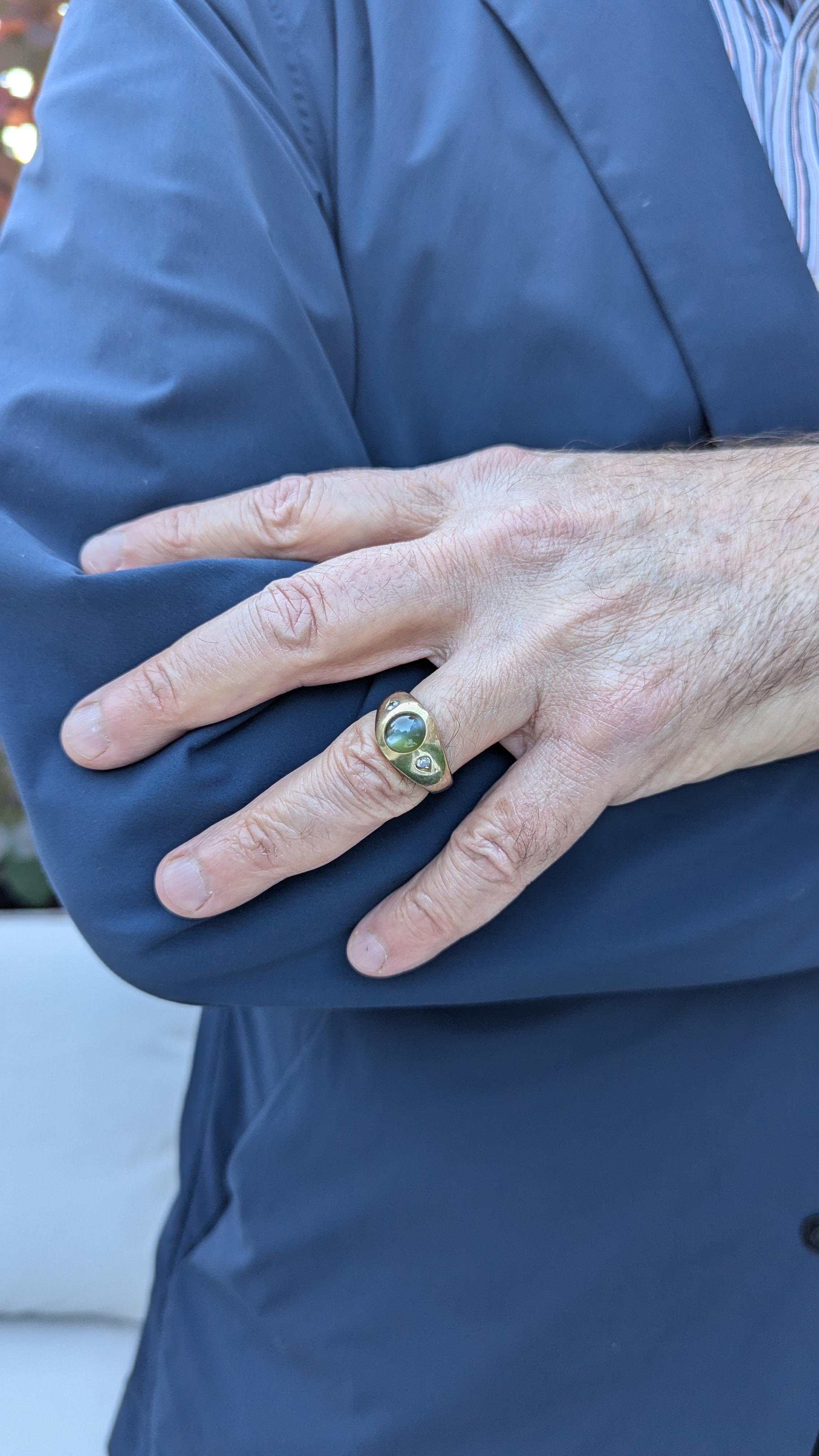 Este anillo de caballero presenta un Ojo de Gato centrado con 2 Diamantes a cada lado, meticulosamente engastados en oro amarillo.