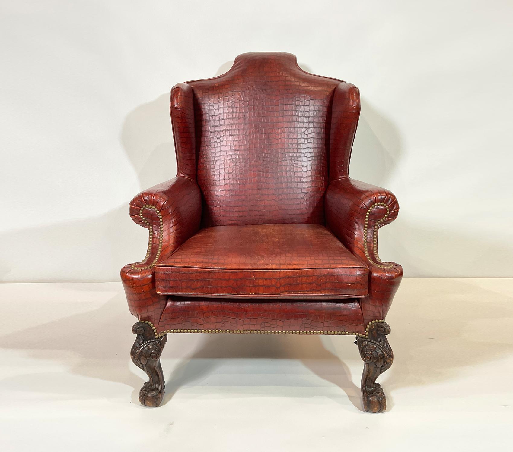 Exuding opulence, the leather library chair boasts a luxurious allure, adorned with a skillfully crafted reptilian aesthetic reminiscent of alligator skin. Its exquisitely carved legs and tasteful brass nail head trim contribute to its premium