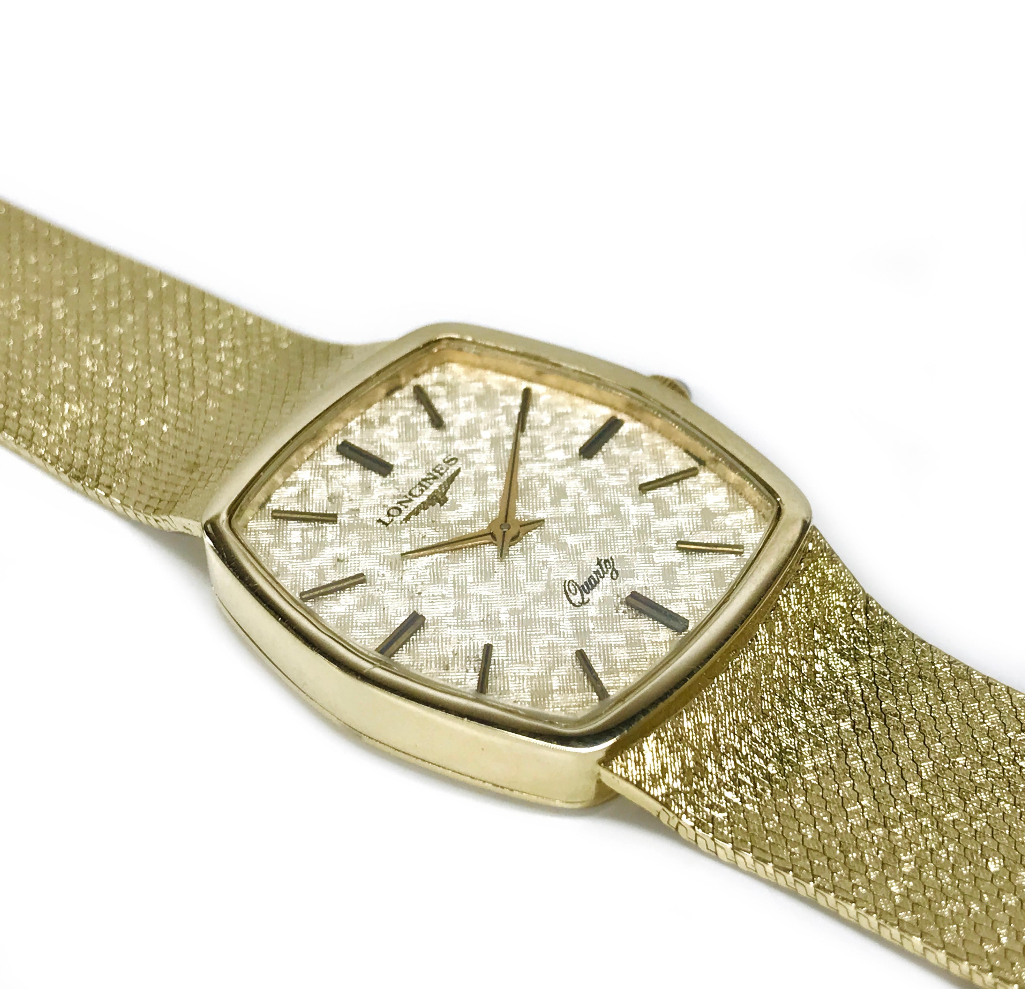 Gentlemen's Longines 14 Karat Gold Watch. This circa 1980s Longines wristwatch features a 14k yellow gold case and mesh-style bracelet with a fold-over style clasp. The watch has gold bar hours and gold alpha-style hour hands. 14k yellow gold