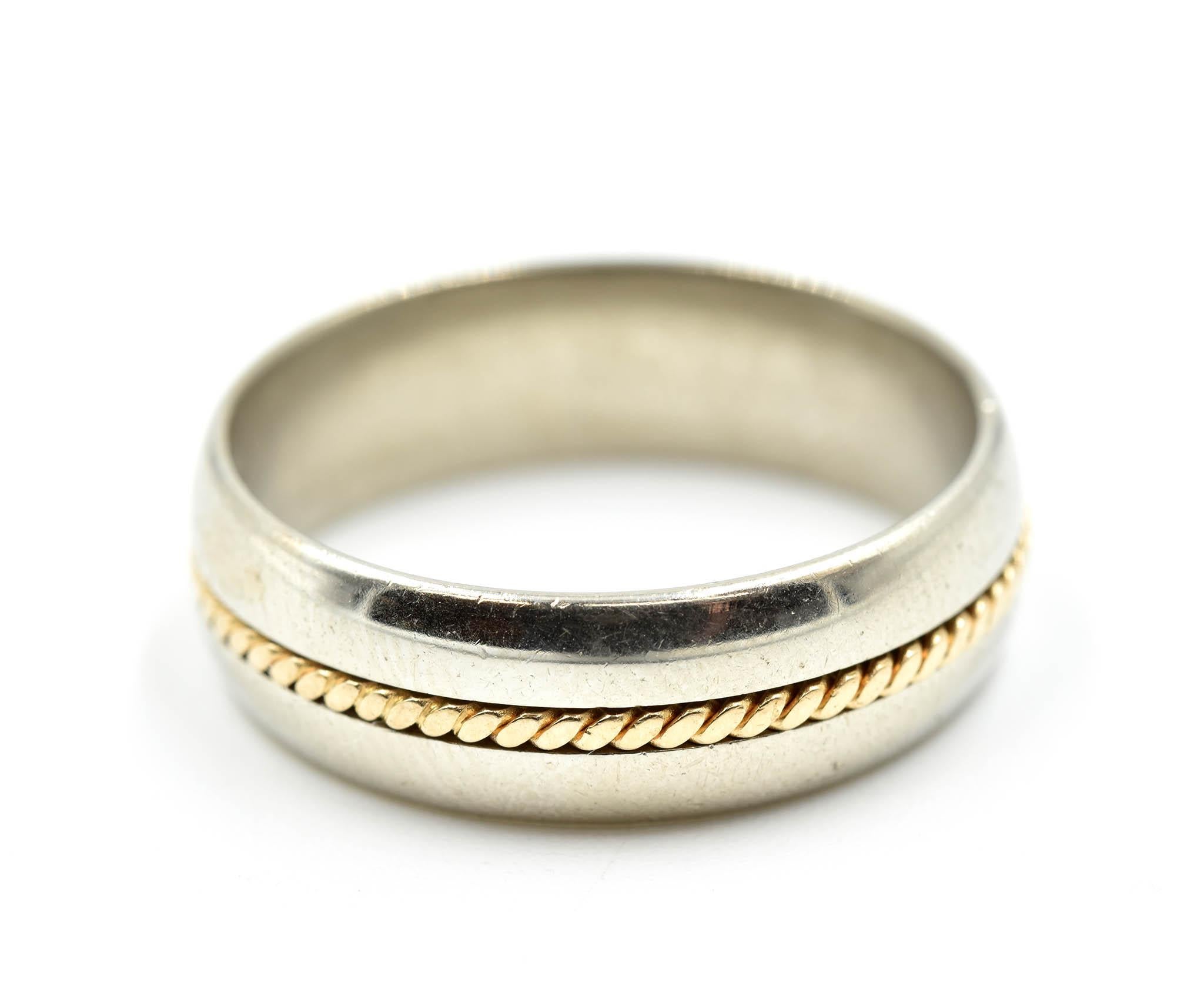 This is a gents wedding band consisting of a 14k yellow gold cable running across the wedding band. The top and bottom of the band is in a high polished 14k white gold. The band measures 6.65mm wide. Band size is 8.5 and total weight is 6.3 grams.