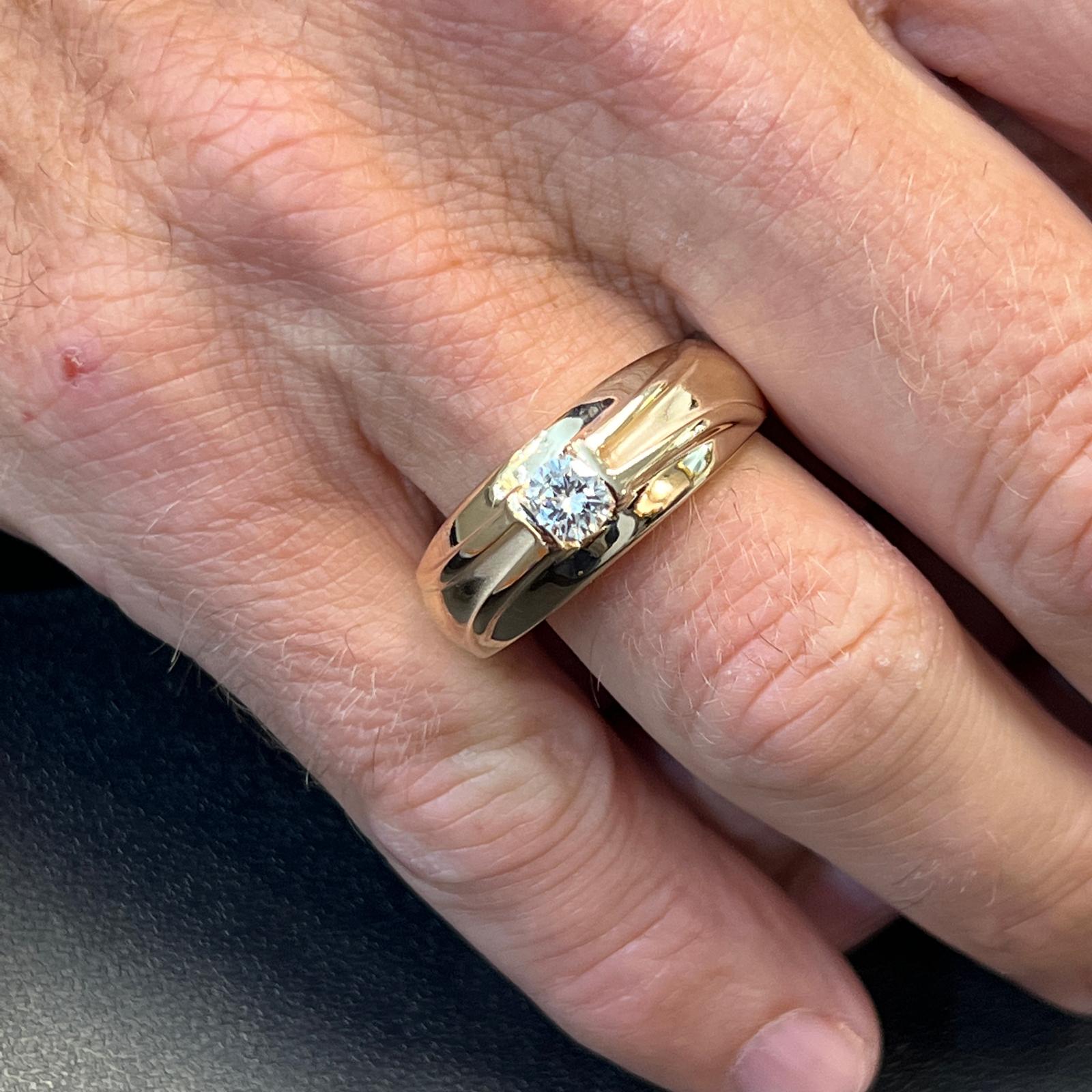 Men's diamond band fashioned in 14 karat yellow gold. The band features an approximately .47 carat round brilliant cut diamond graded H color and SI1 clarity. The band measures 5mm in width and is currently size 11.5 (can be sized). 