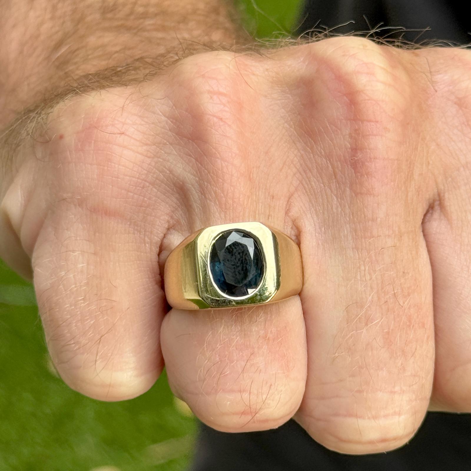 Herrenring mit blauem Saphir, gefertigt aus 18 Karat Gelbgold. Der Ring ist mit einem ovalen, natürlichen blauen Saphir von ca. 4,0 Karat besetzt. Der Ring misst 12,5 mm in der Breite und hat derzeit die Größe 8,75 (kann angepasst werden). Gewicht: