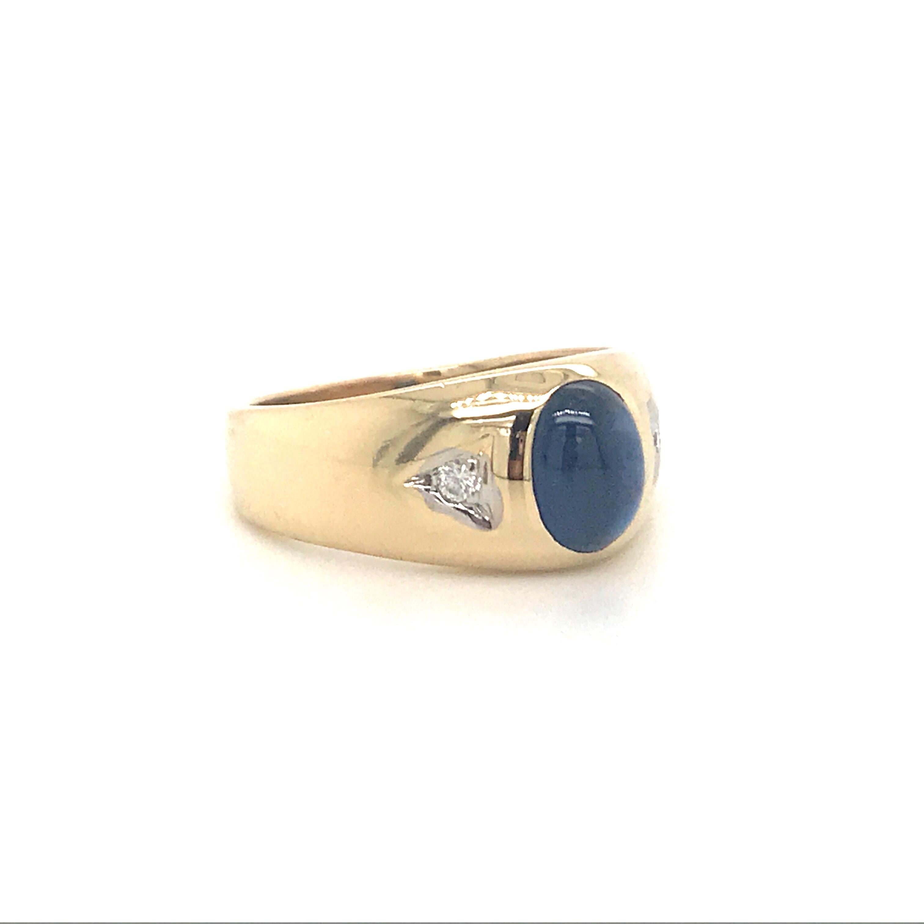 14K Yellow gold Gents ring featuring one cabochon oval sapphire with two round brilliants. 
Sapphire is treated.