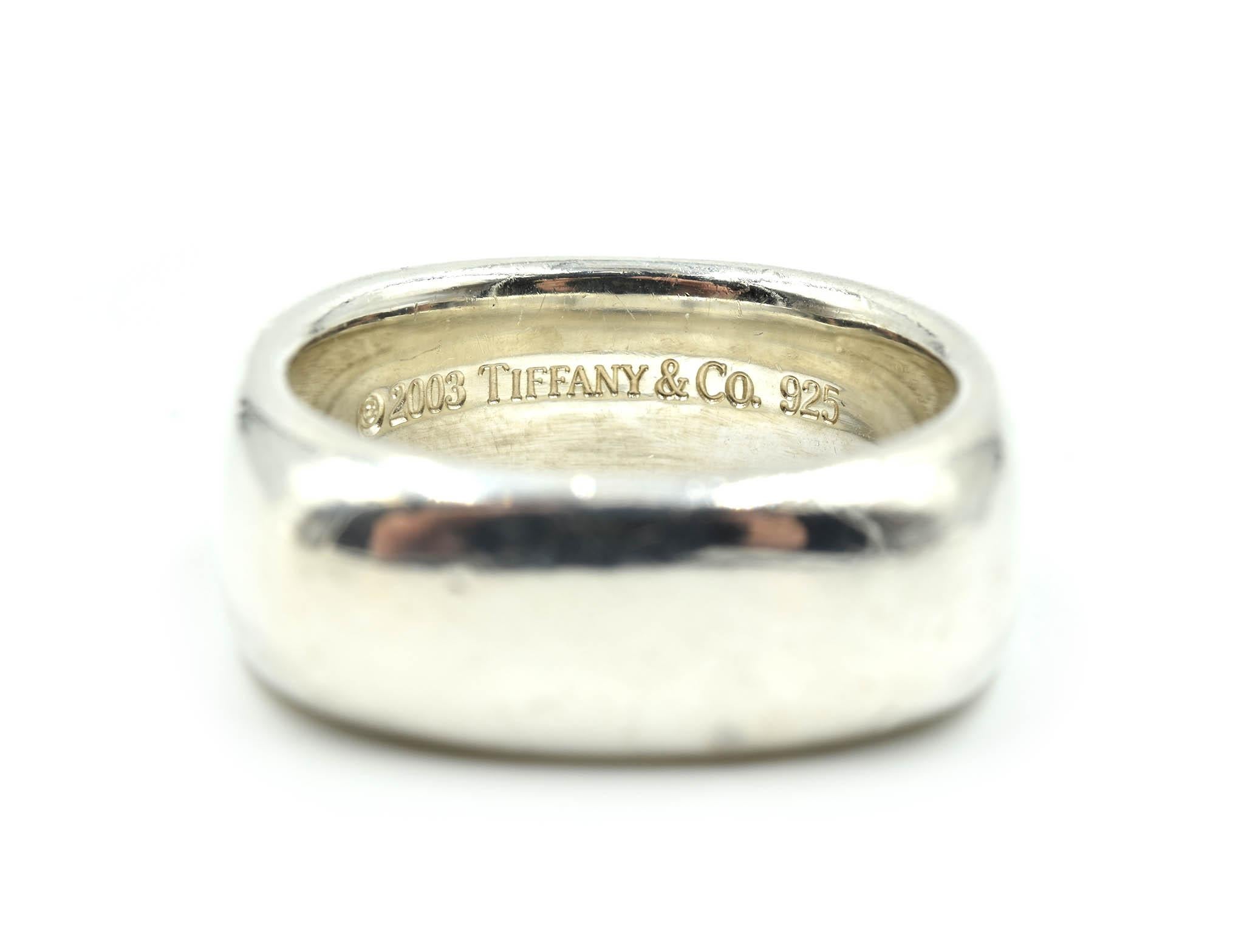 This is a timeless design by a classic designer! Tiffany & Co made this gents wedding ring in high polished sterling silver with a squared band! The band is size 8 1/4; and measures 8.11mm in length and 2.68mm in width at the shank. The wedding band