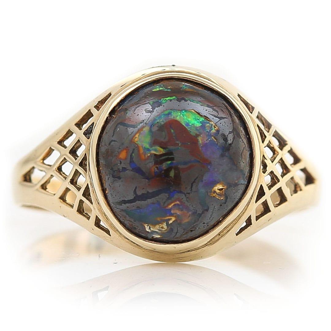 A great vintage gentlemen’s 9ct gold signet ring dating from circa 1980 the ring has a central set opal with flashes of electric blue, purple and green. The opal is set in its matrix (base material) as it would have been whilst forming over millions