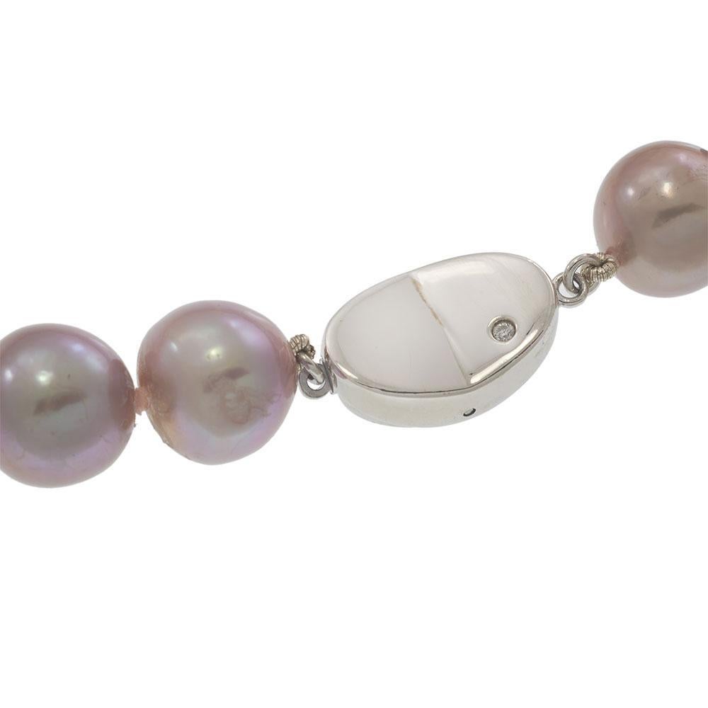 Elegante en su tono y atemporal en su silueta, este collar de auténticas perlas rosas aporta un suave brillo a cualquier ocasión. Con un diámetro de entre 11 mm y 14 mm, cada perla presenta una variación natural y un tono rosado con una rica