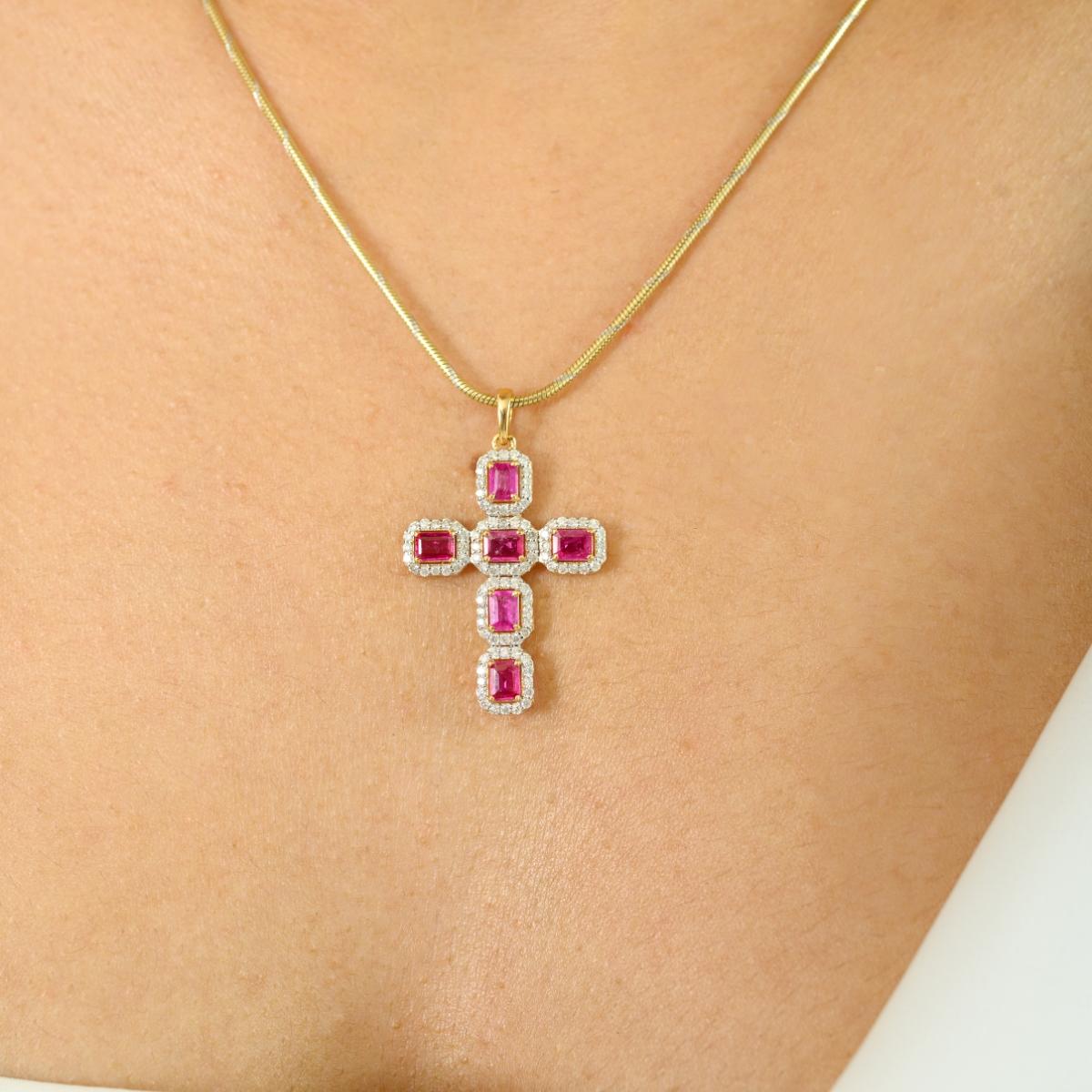 Célébrez la foi intemporelle et l'élégance vibrante avec ce saisissant pendentif en forme de croix, façonné dans un riche or jaune 18K. Cette pièce sophistiquée présente 1,10 carats de rubis roses vifs, chacun taillé en émeraude et disposé en une