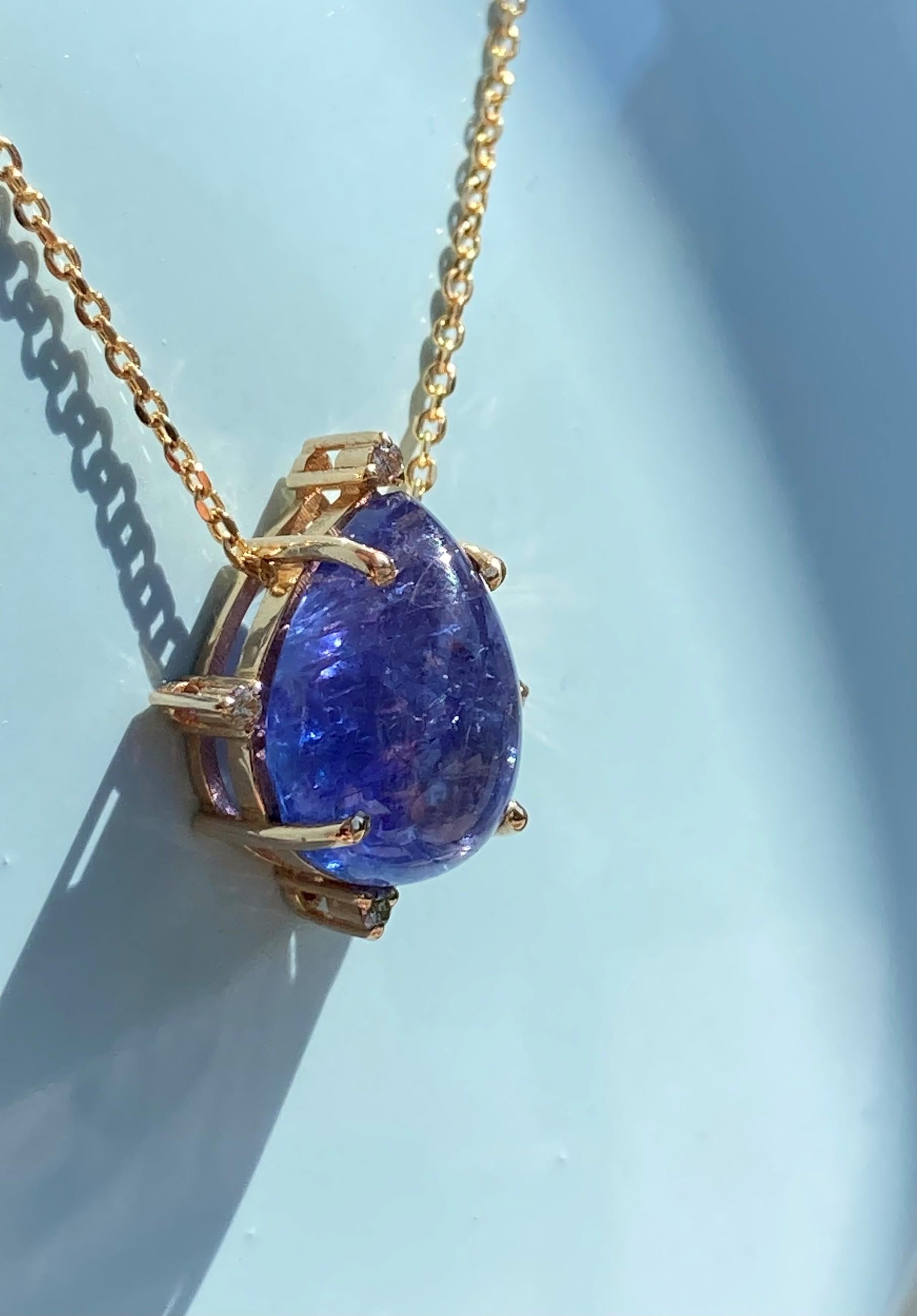 Un impressionnant pendentif en Tanzanite, unique en son genre, serti dans de l'or jaune massif 14 carats, entouré de diamants naturels étincelants. L'éblouissante tanzanite géante a une couleur violette intense envoûtante et est sertie dans de l'or