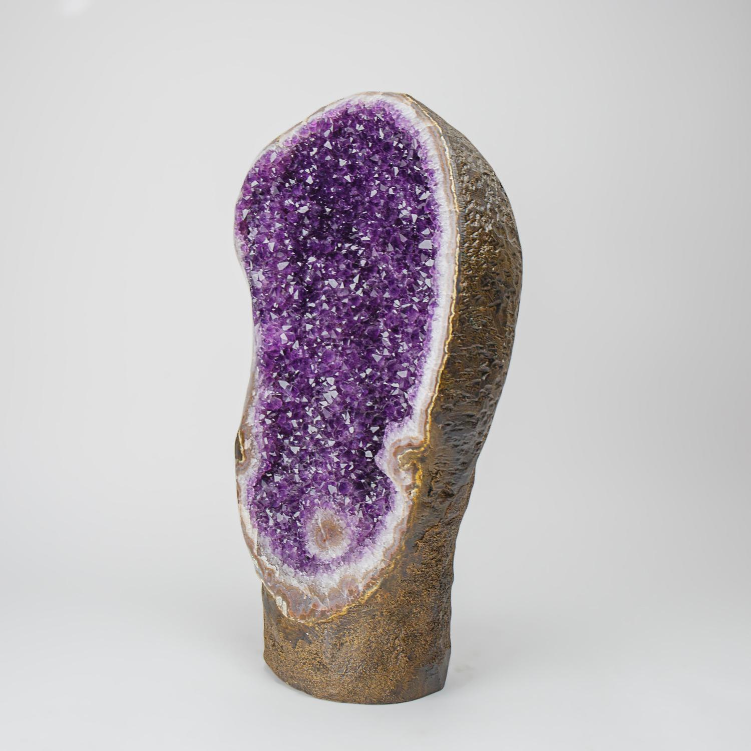This Genuine Amethyst Cluster Geode from Uruguay is a top quality natural formation of gem amethyst. The half geode cathedral decor features lustrous fully terminated crystals with highly reflective faces and a deep, transparent to translucent grape