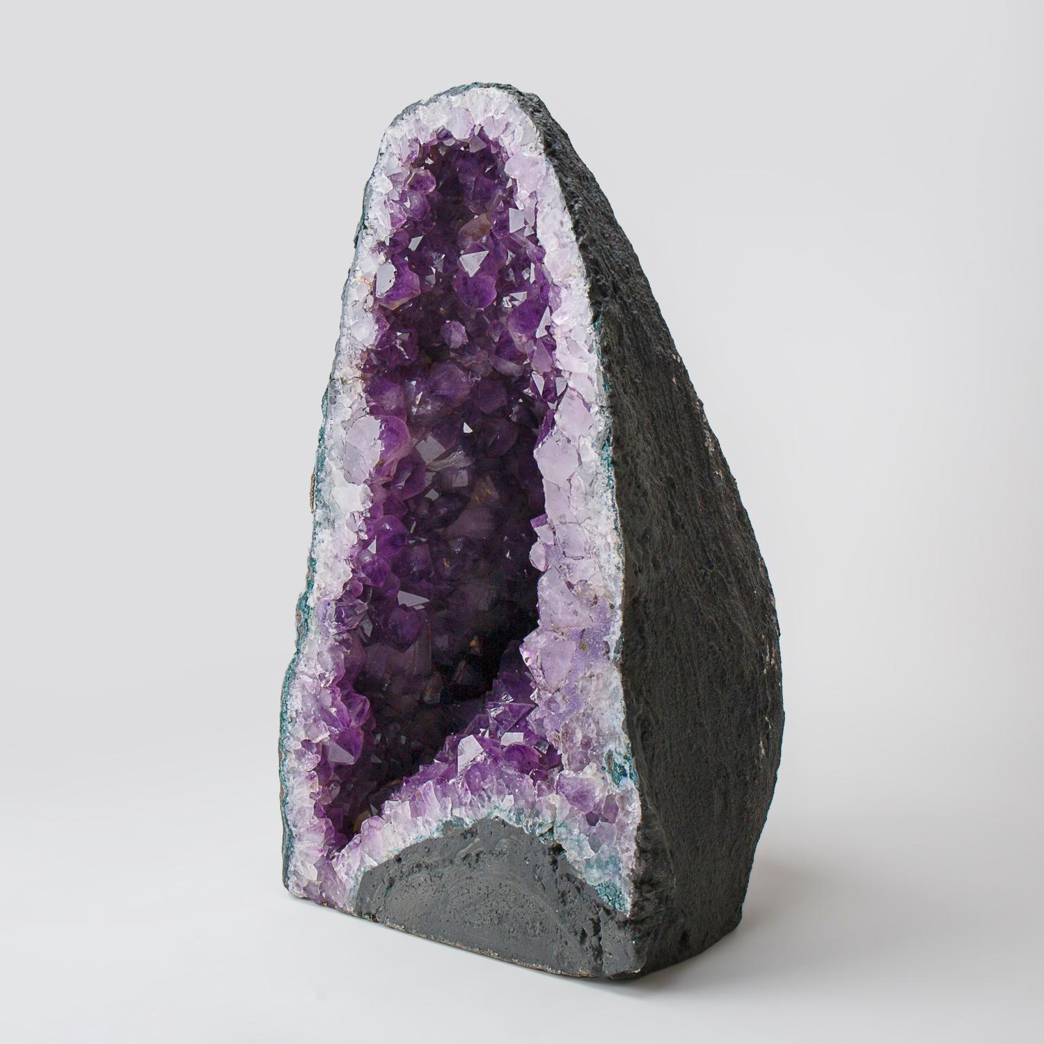 This Genuine Amethyst Cluster Geode from Brazil is a top quality natural formation of gem amethyst. The half geode cathedral decor features lustrous fully terminated crystals with highly reflective faces and a deep, transparent to translucent grape